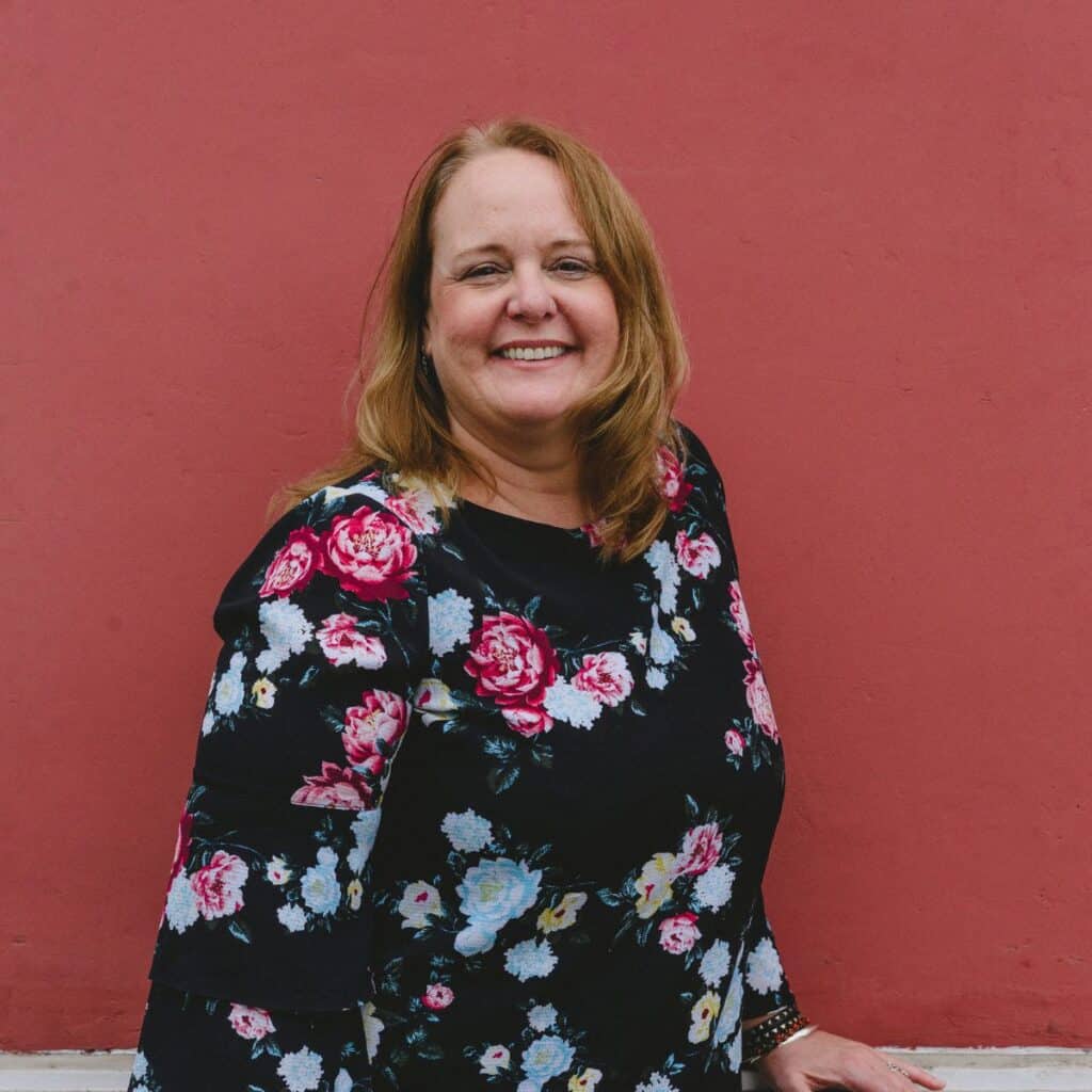 Picture of Lyn in front of a red background.