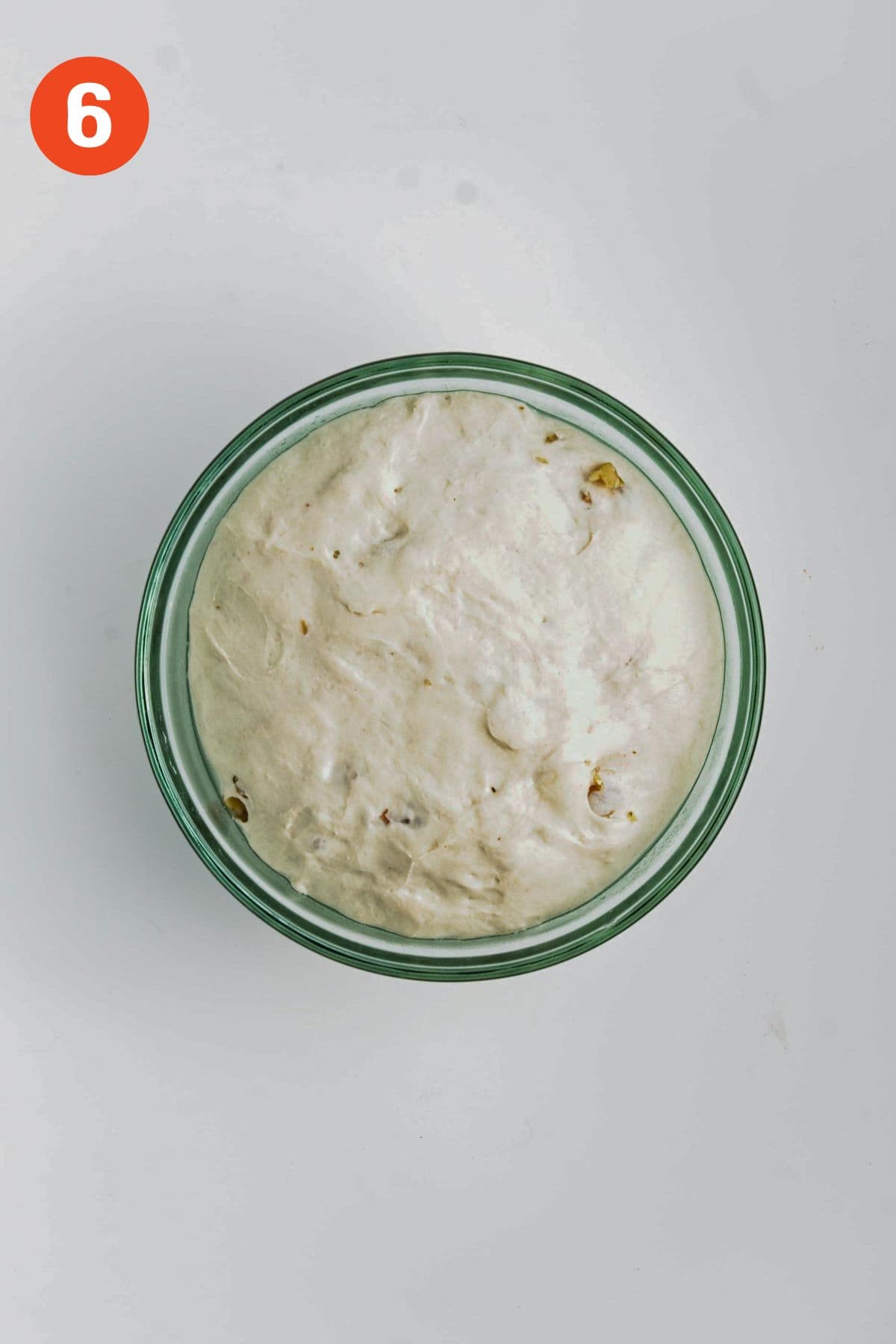 Proofed dinner roll dough in a bowl.