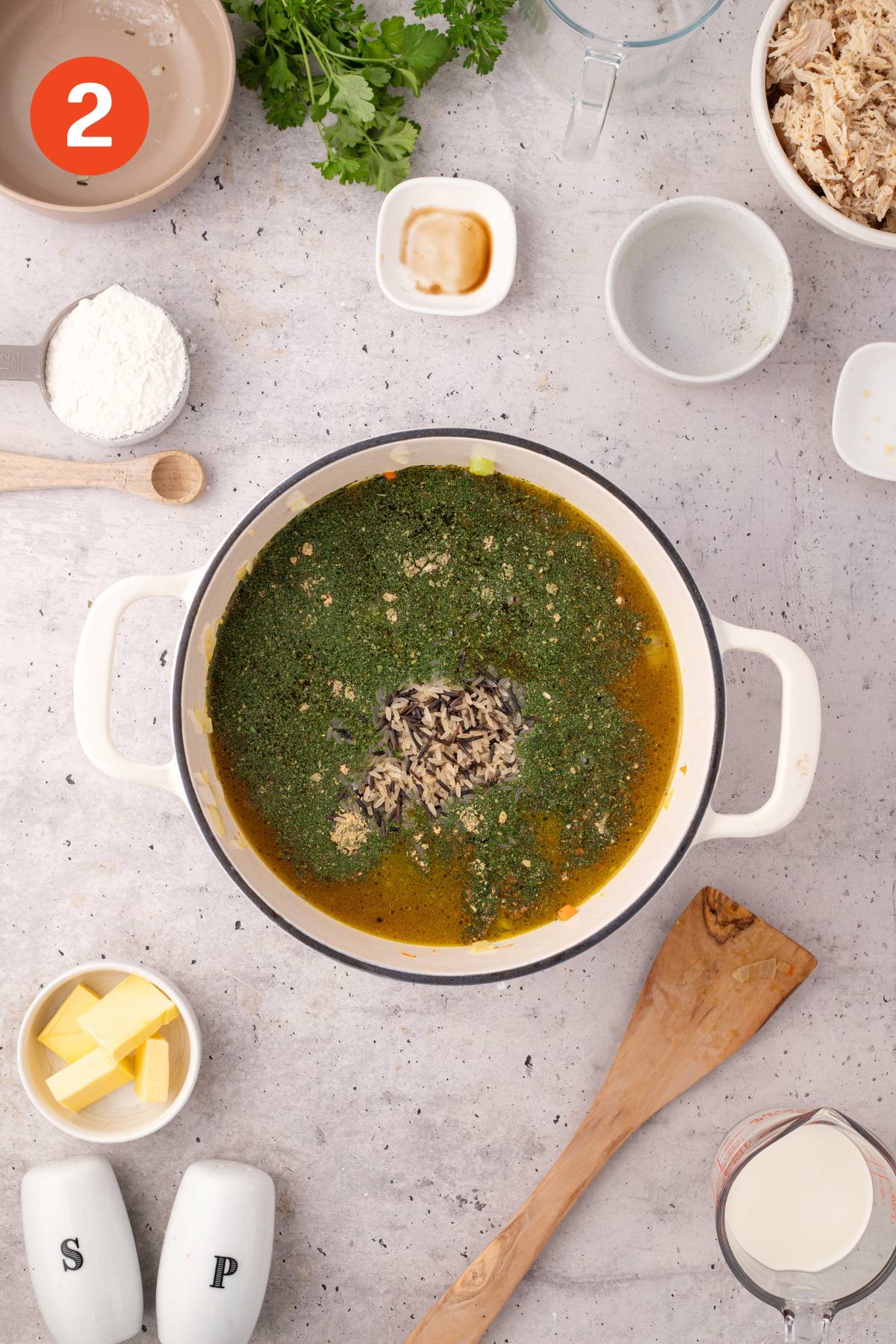 Broth and seasoning pack added to the vegetables in a pot.