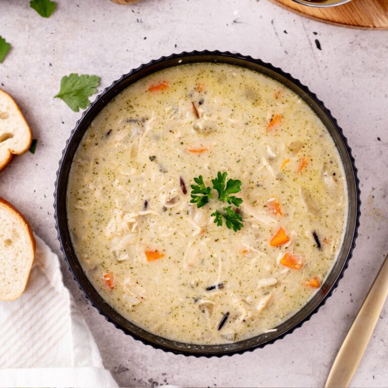 A bowl of chicken wild rice soup garnished with parsley.