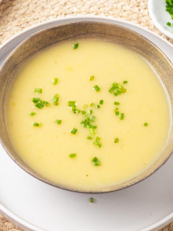 A bowl of Instant Pot potato leek soup on a white plate.