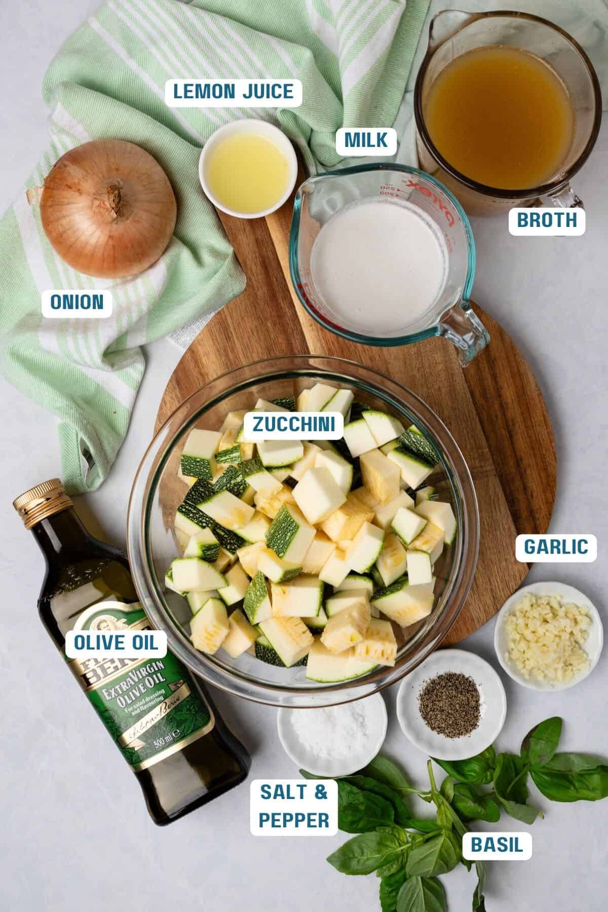 Ingredients to make zucchini soup on the table with text labels to the side.