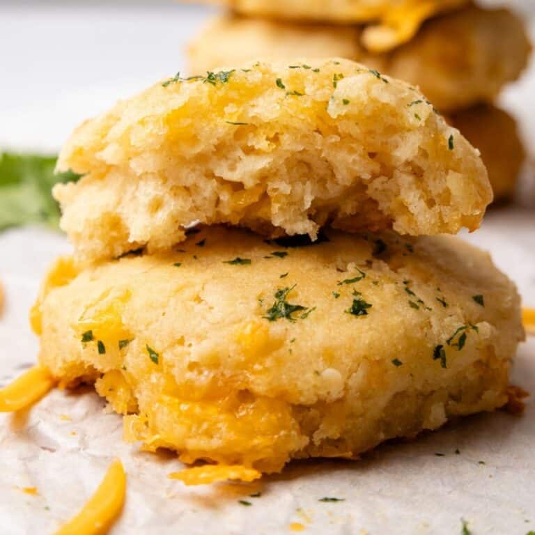 A cheddar split in half to show inside stacked on top of another one.