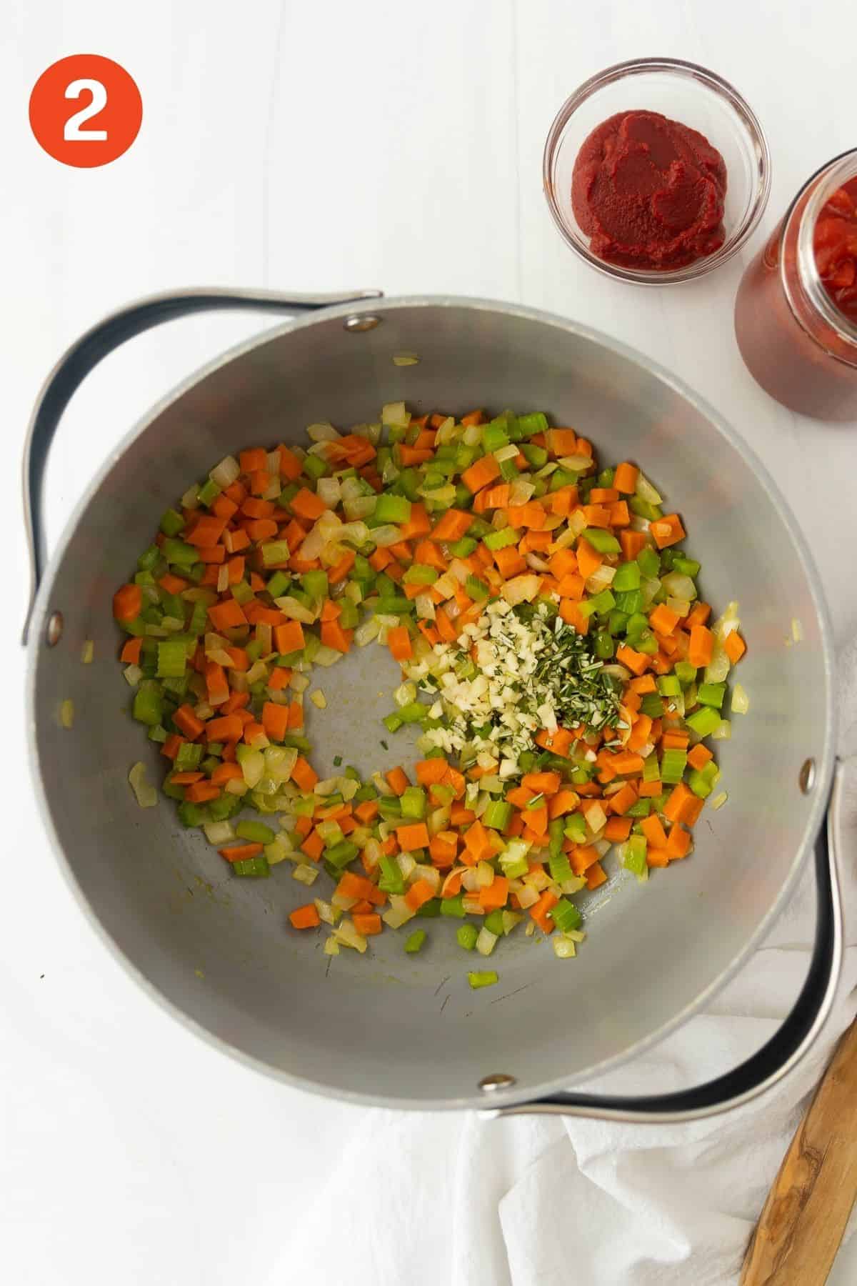 Cooked vegetables in a pot with garlic added.