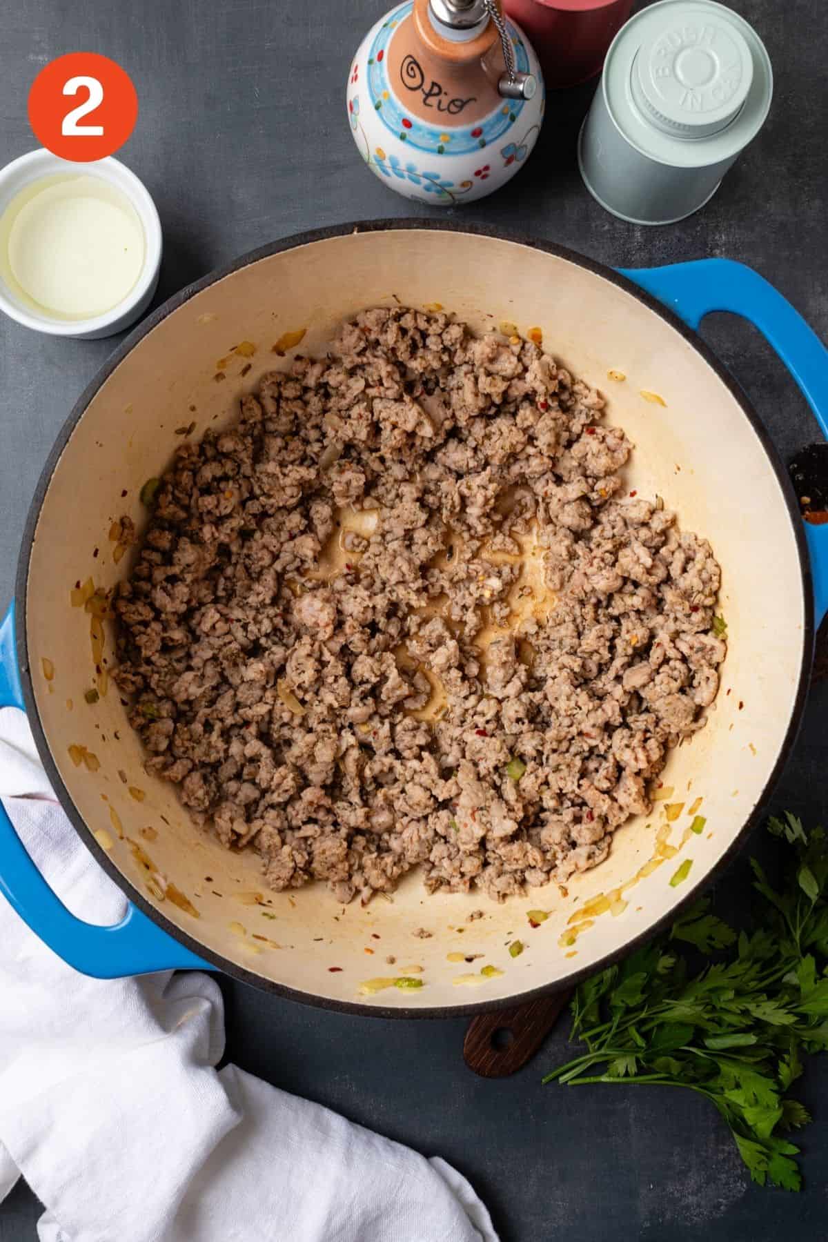 Italian sausage cooking in a pot.