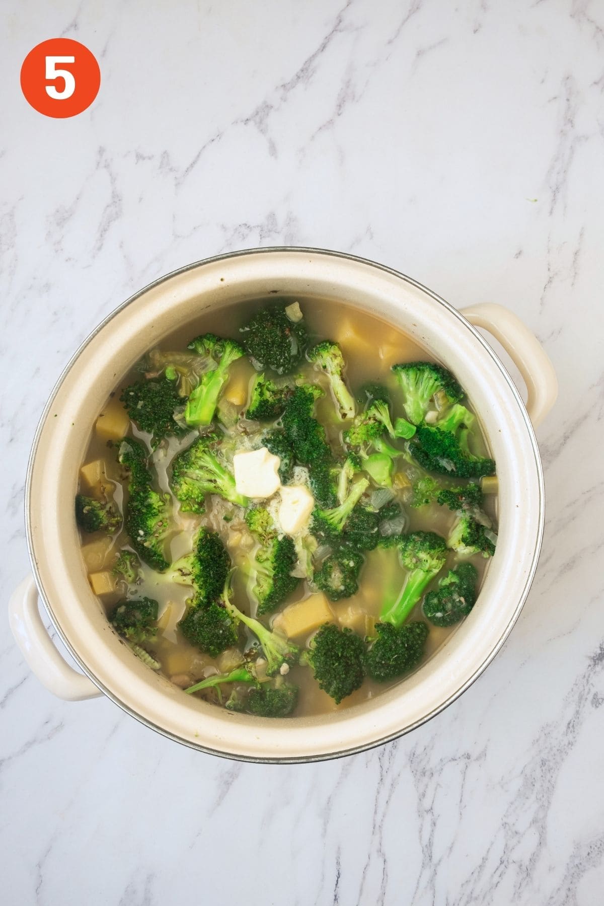 Broccoli added to the pot of potato soup.