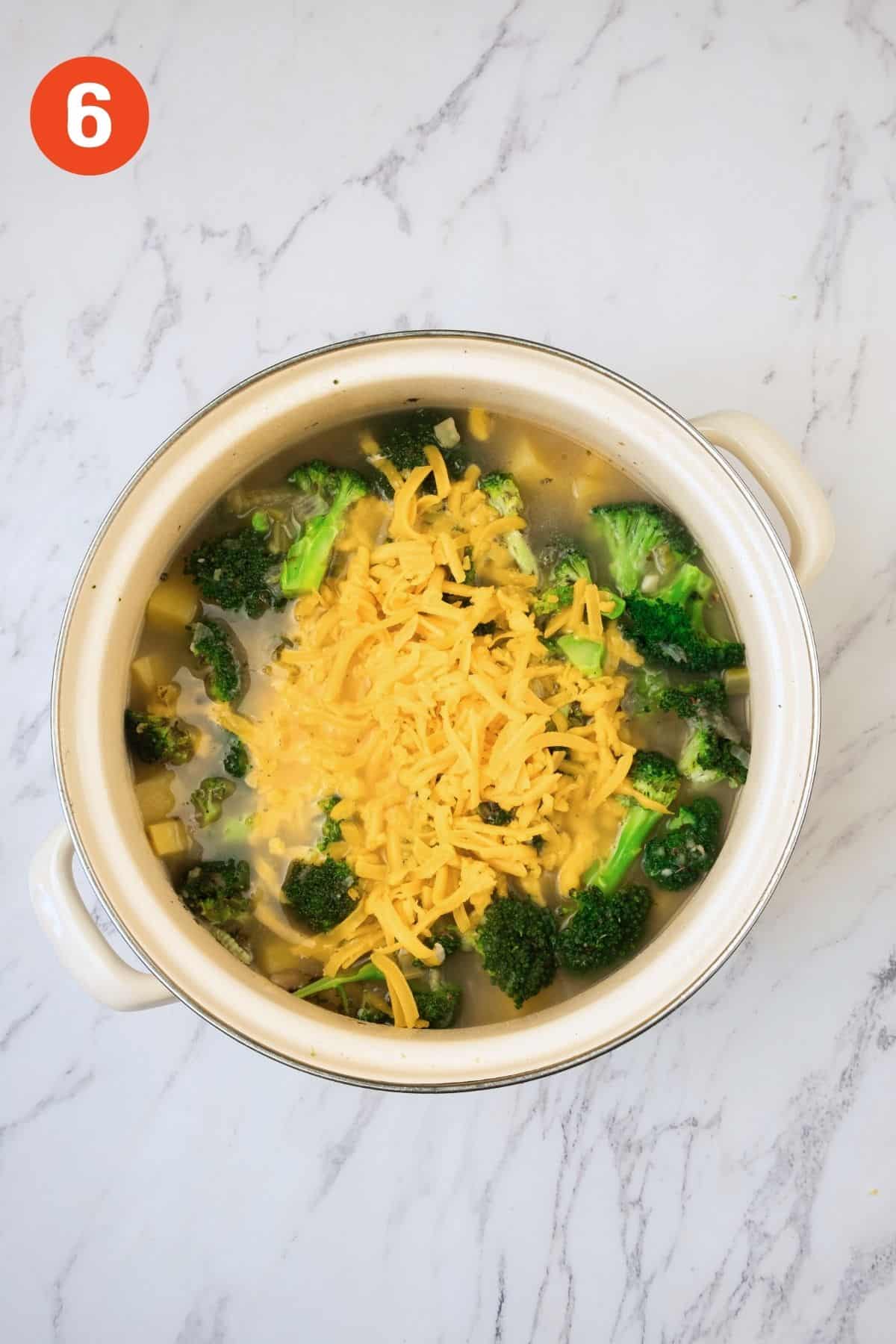 Shredded cheddar added to the pot.