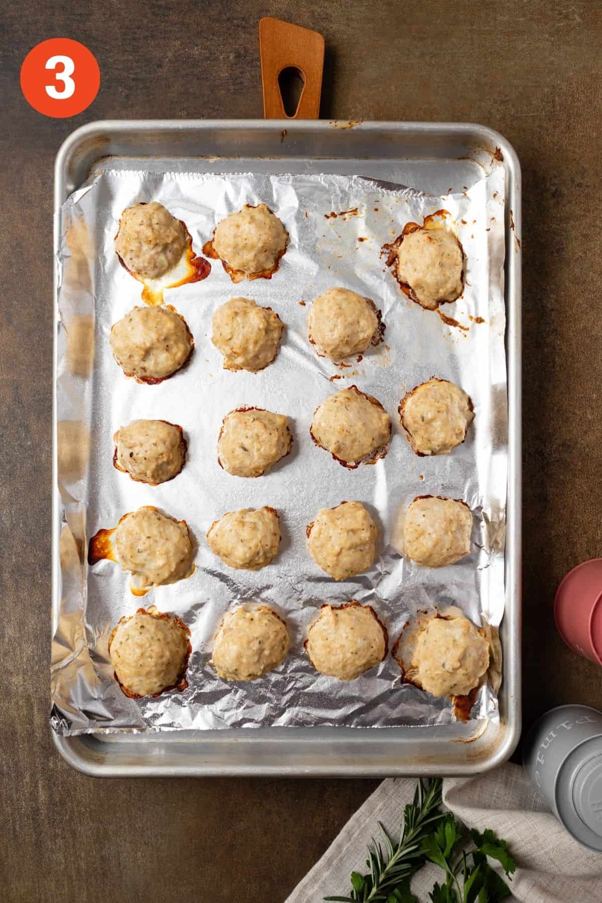 Chicken meatballs on a baking tray after cooking.