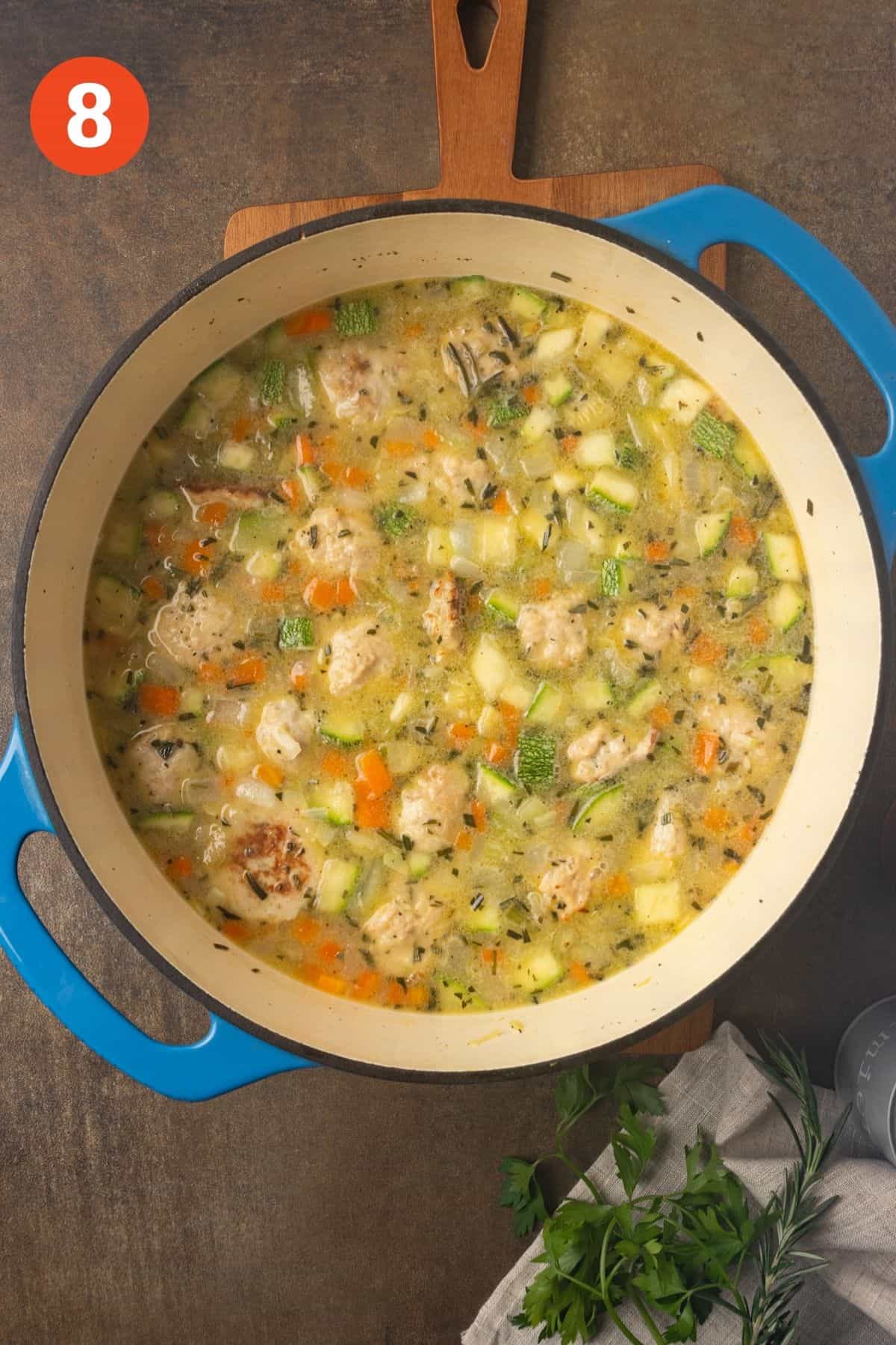 Chicken meatballs are added to the pot with the vegetables.