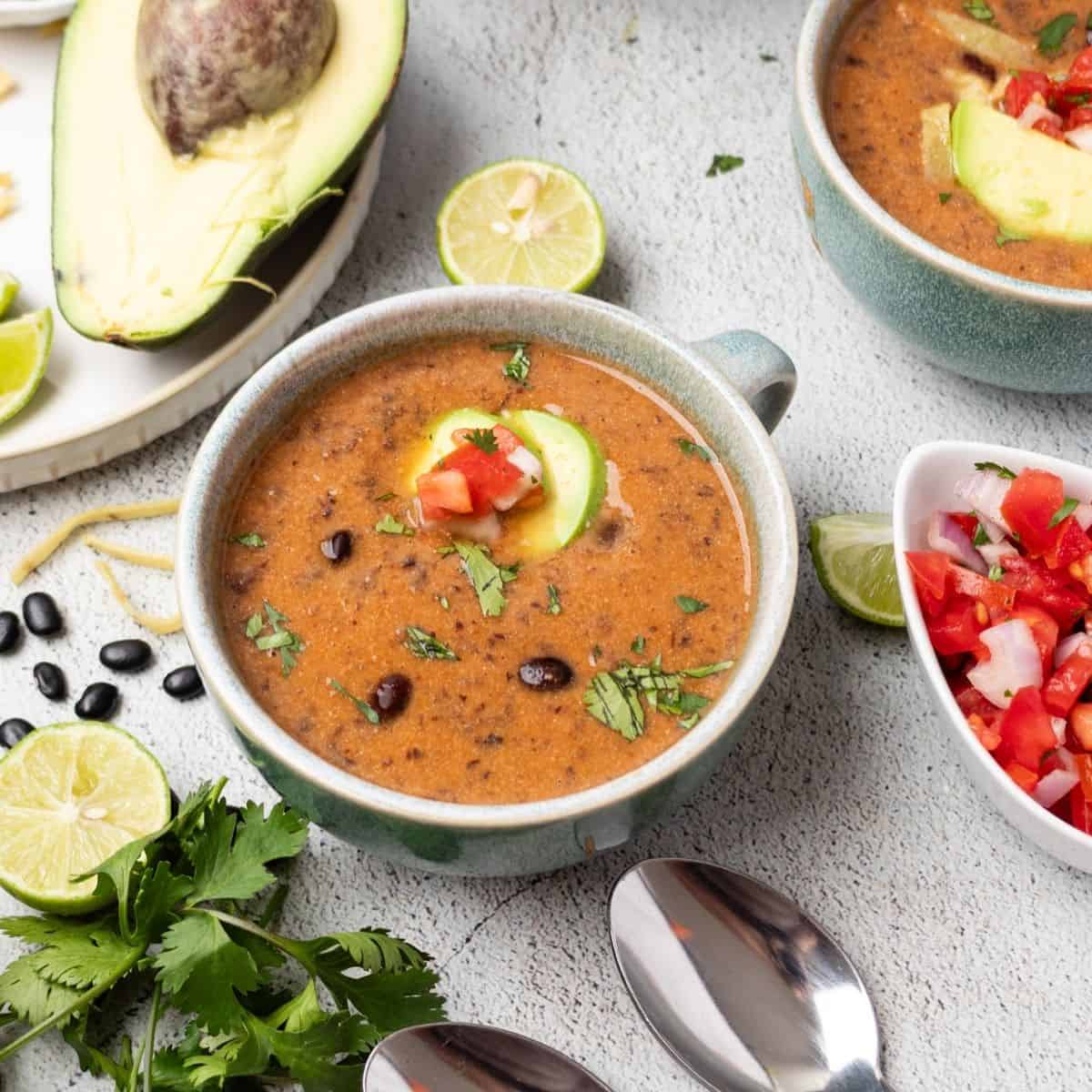 Instant pot black bean soup topped with pico de gallo and avocado.