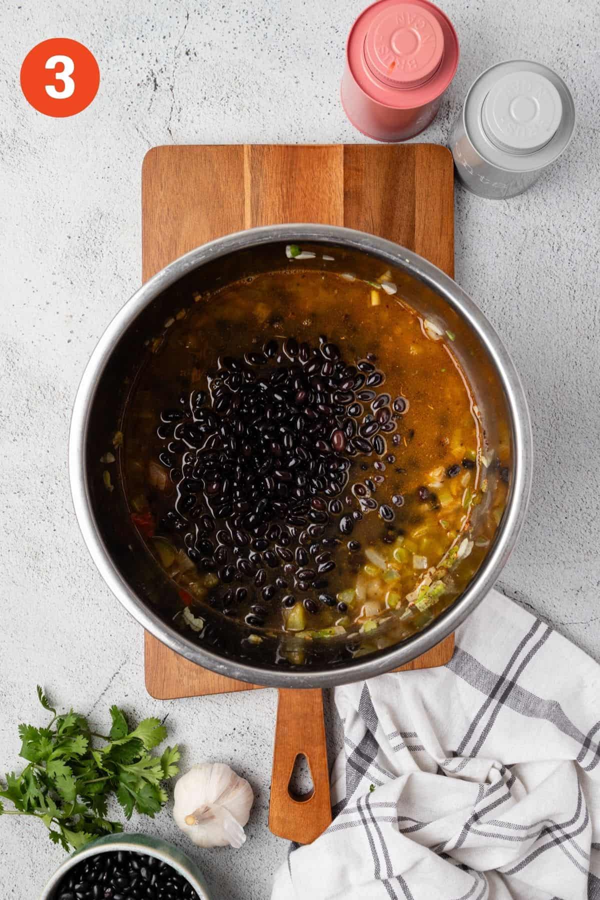 Black beans and broth added to the Instant Pot.