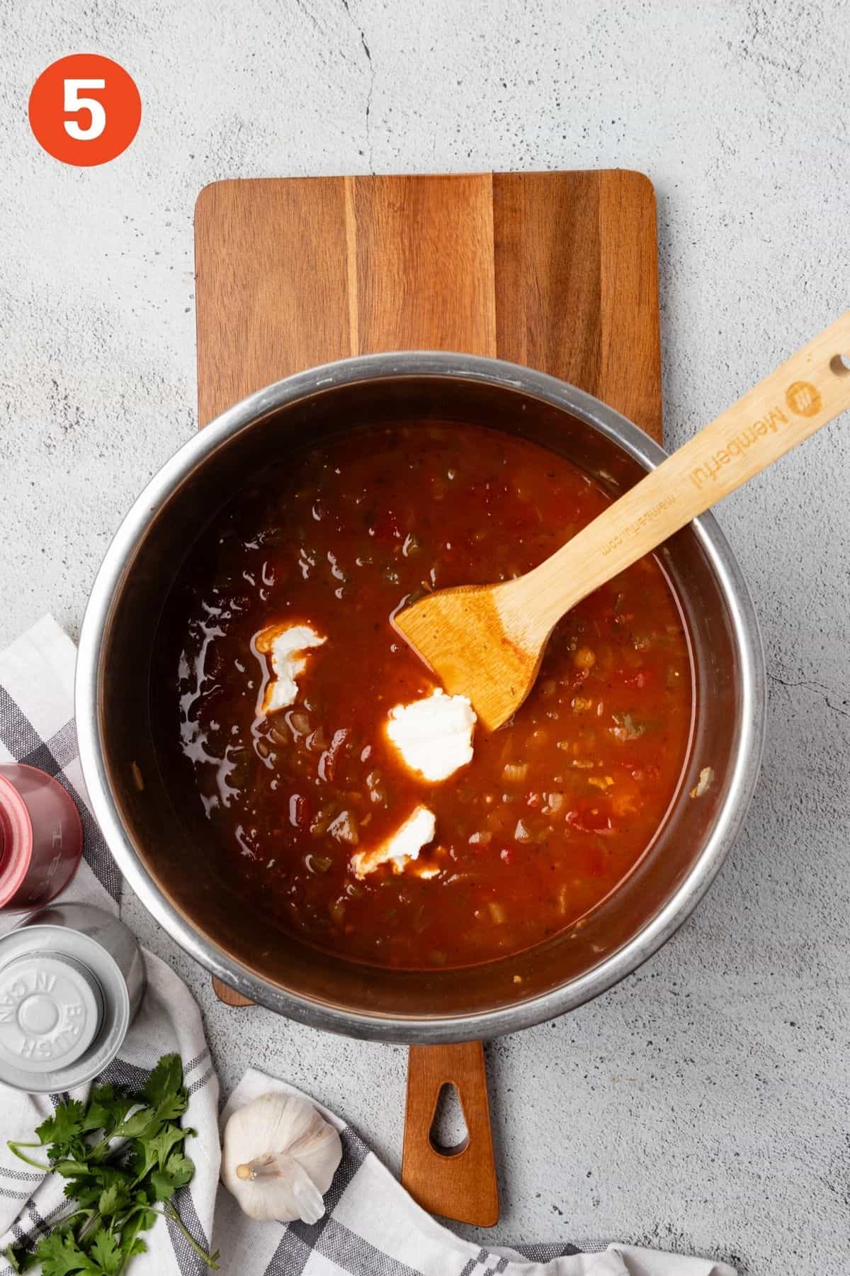 Sour cream added to black bean soup.