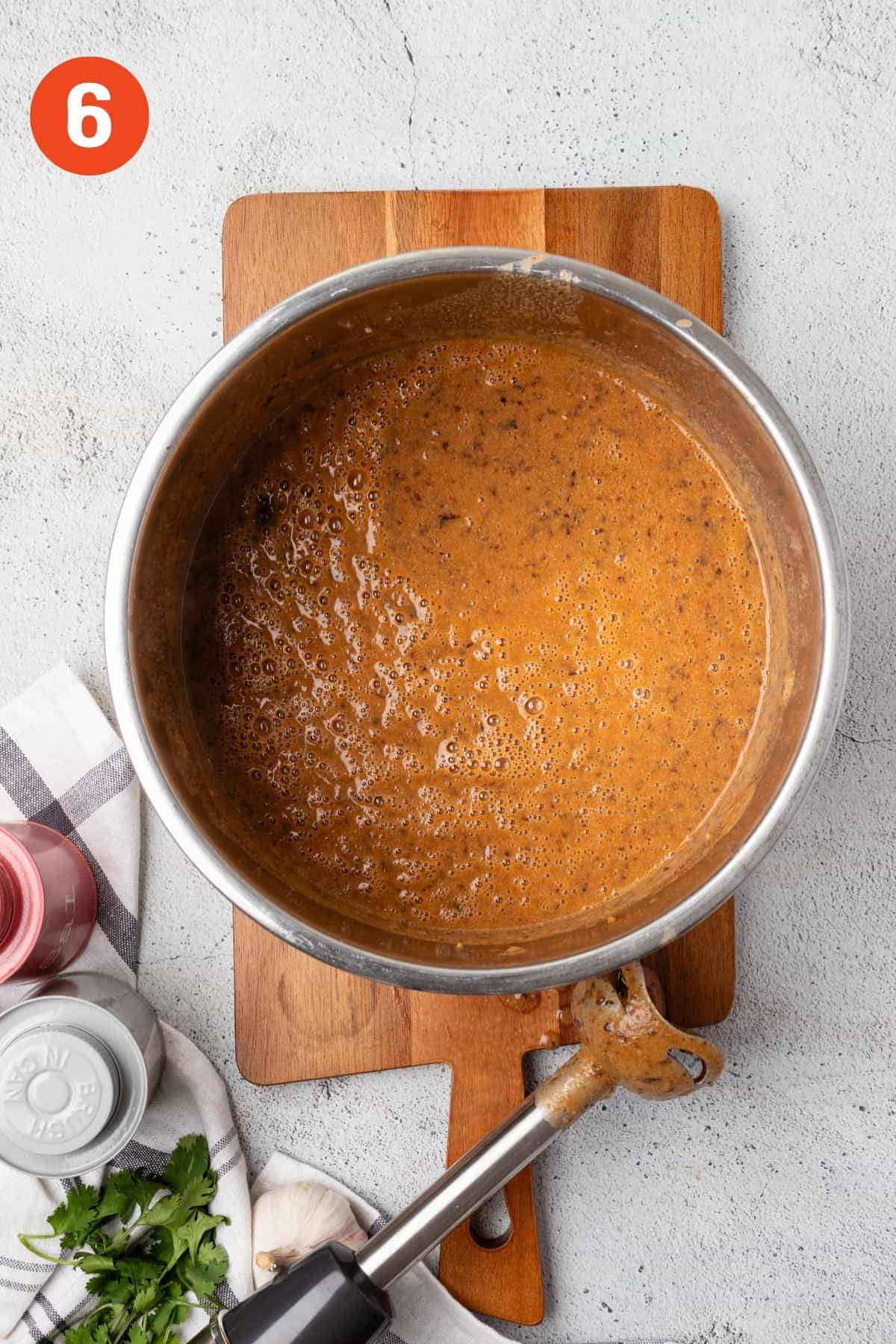 Pureed soup with an immersion blender resting to the side.
