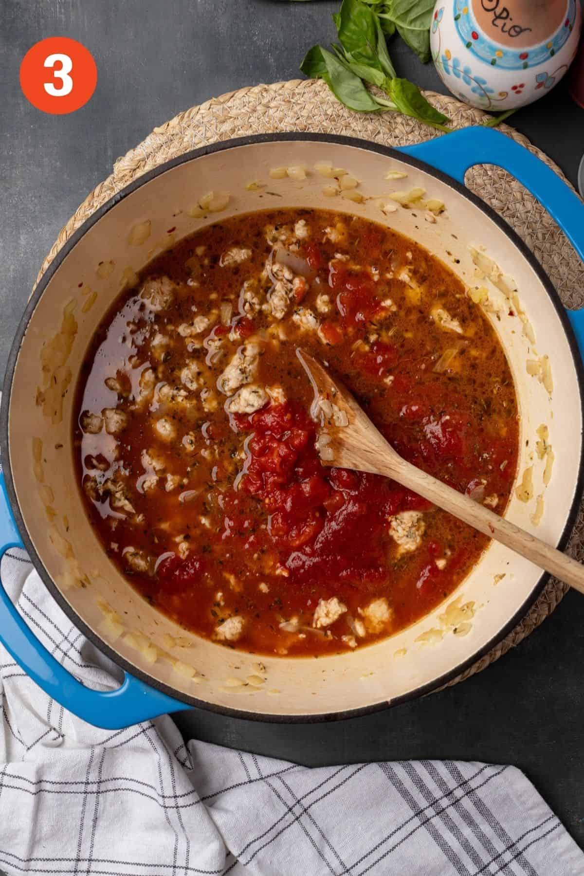 Broth and tomatoes added to the pot. 