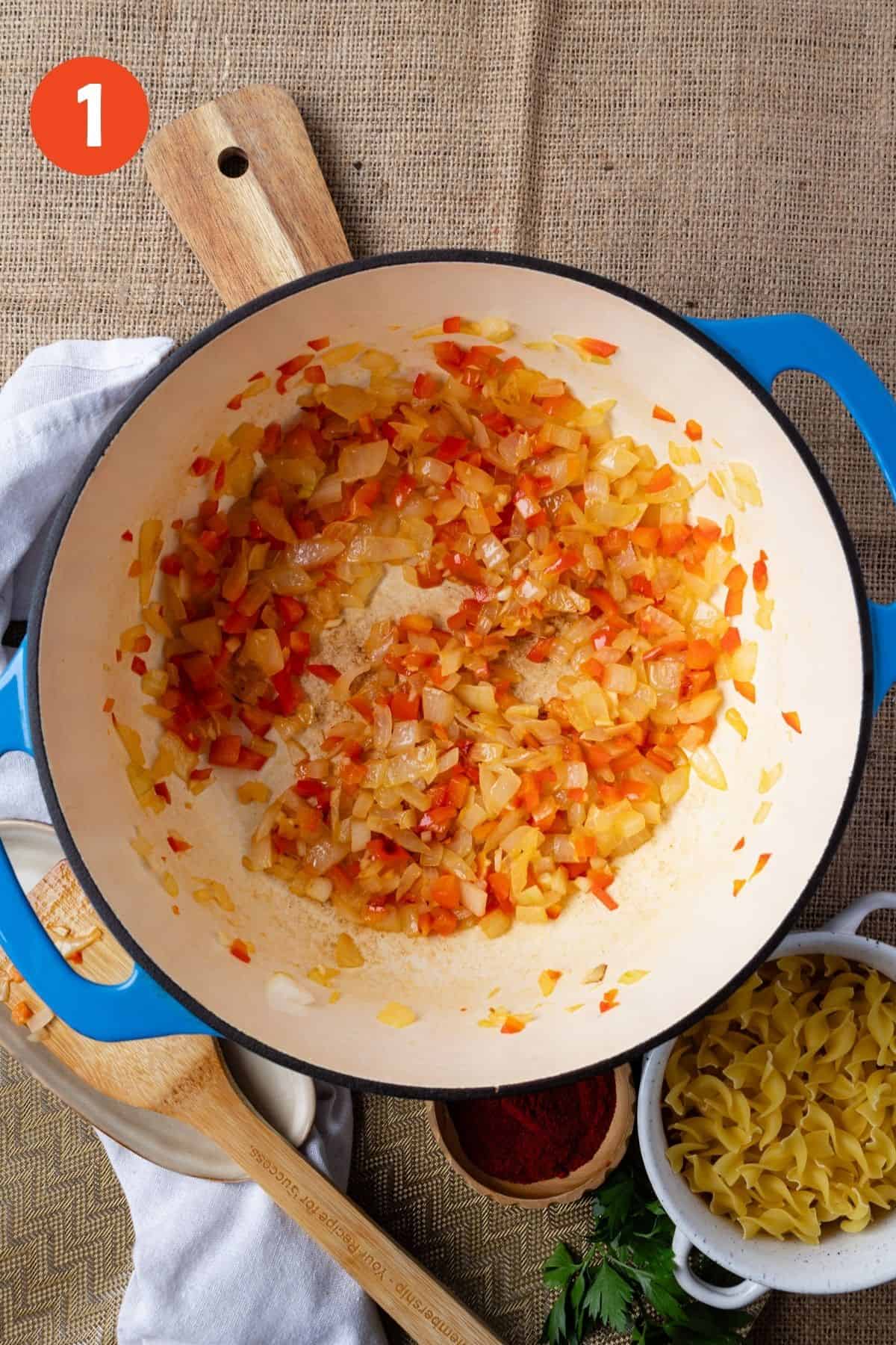 Onions and bell pepper cooking in a pot.