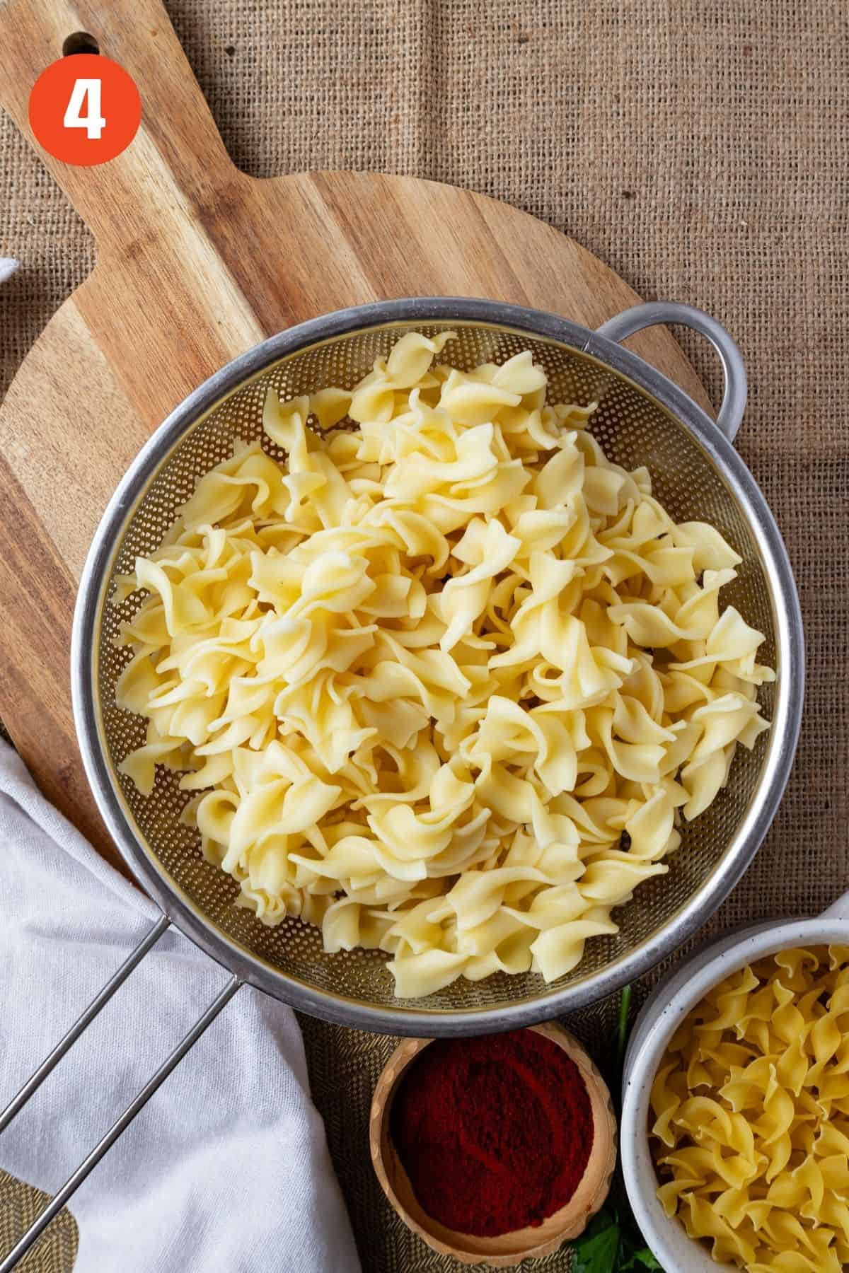 Egg noodles in a strainer.