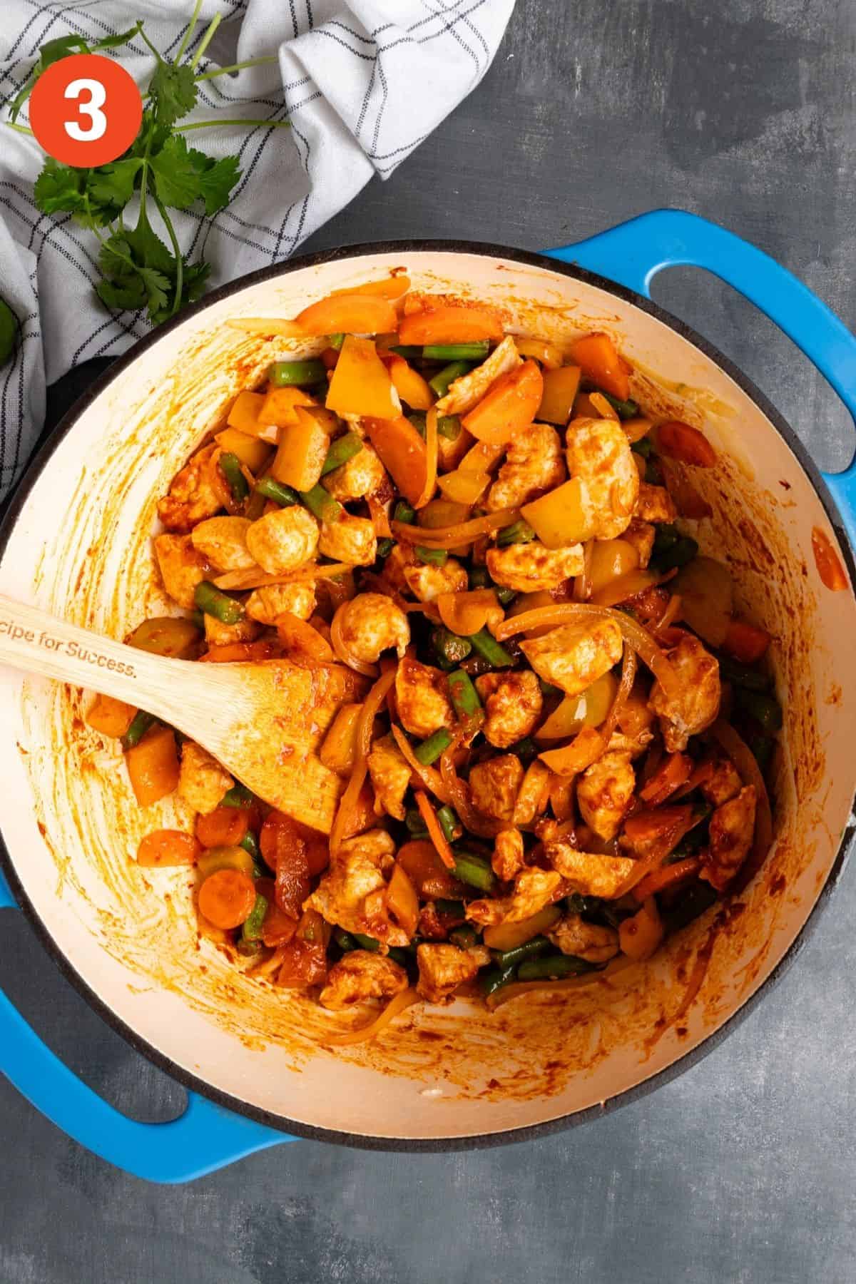 Red chili paste added to the vegetables and chicken to bloom.