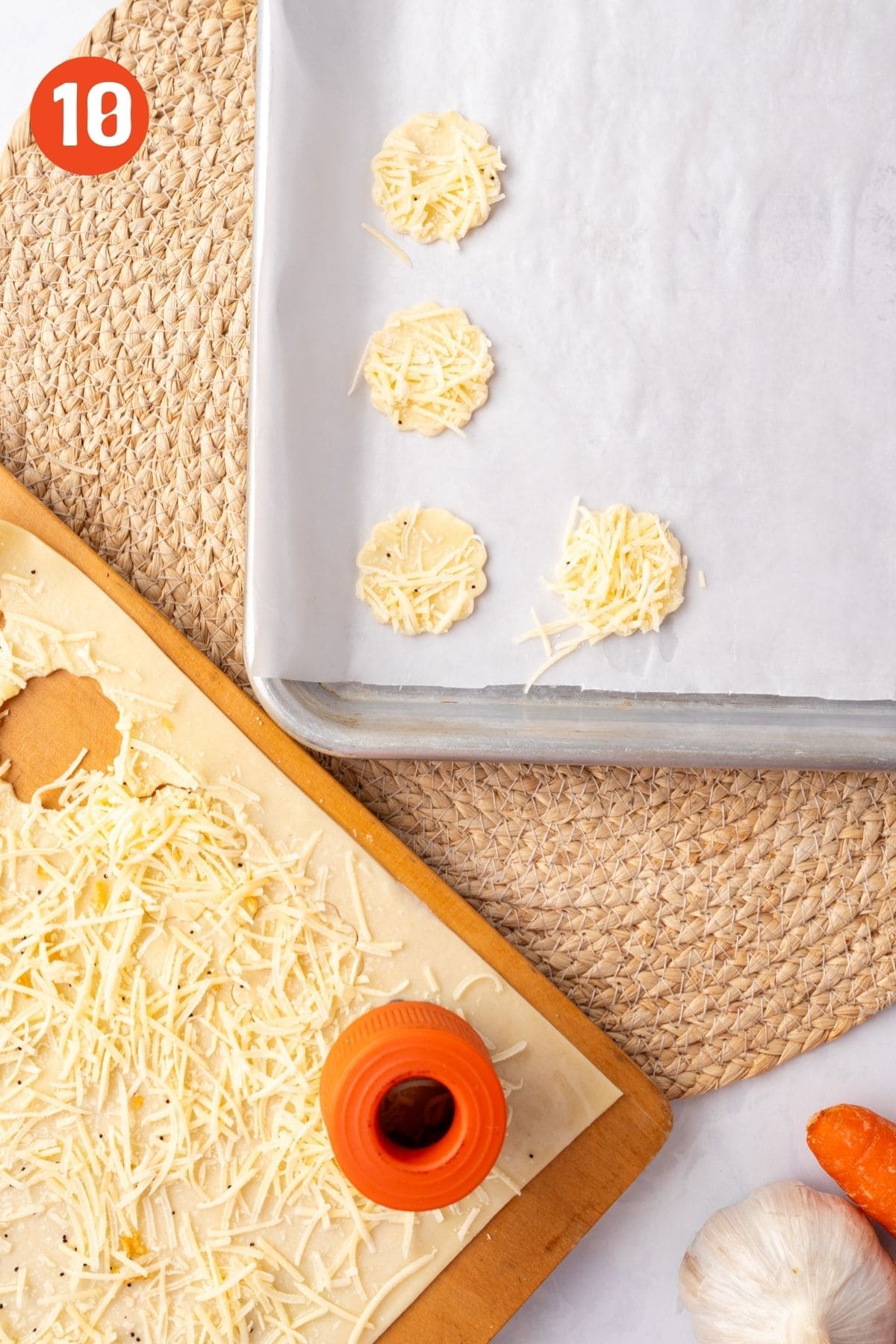 Puff pastry cutouts laid on a baking sheet and more being cut on the puff pastry.