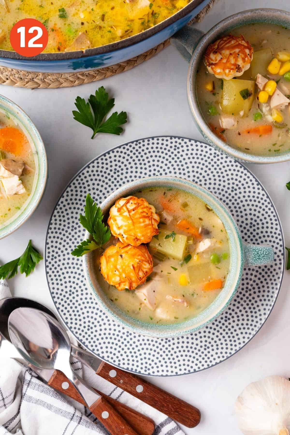 A bowl of soup on a plate topped with a puff pastry cutout.