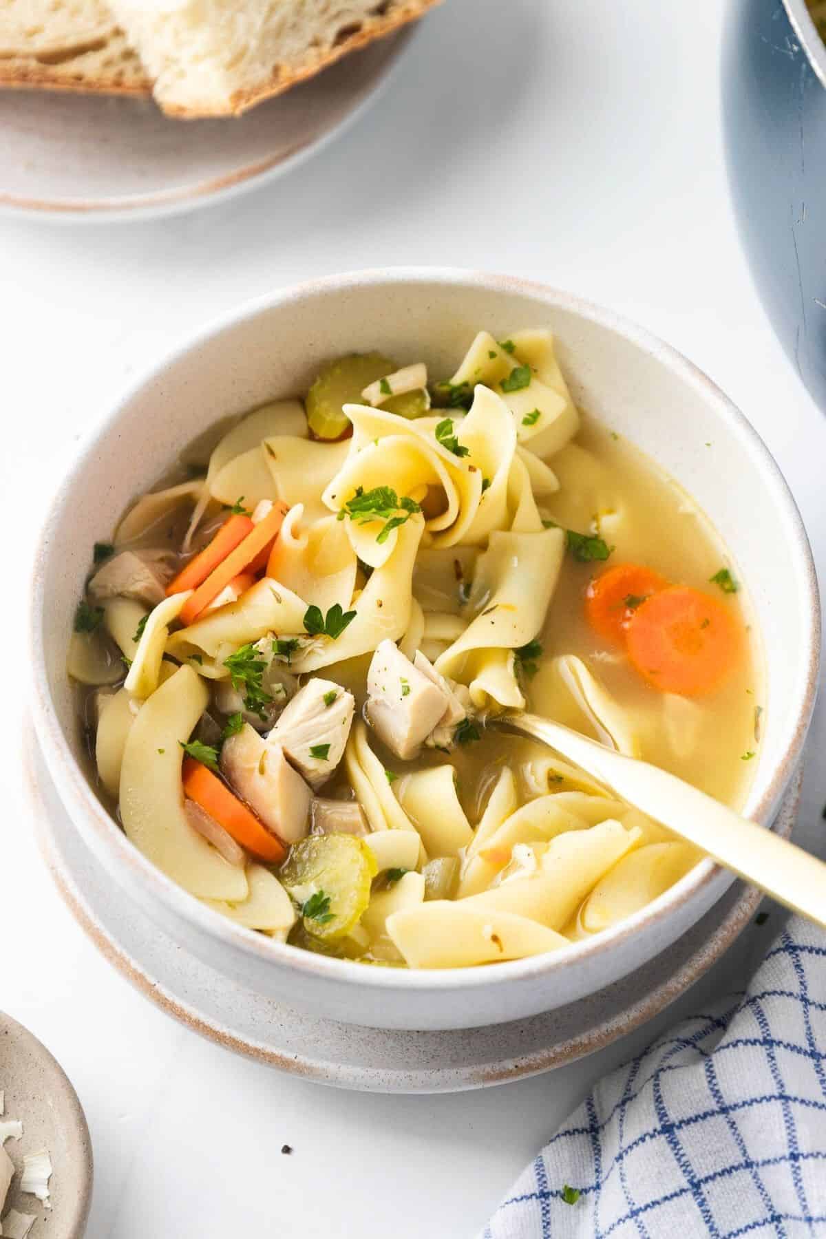 A bowl of copycat Panera soup on a tabletop with a spoon resting in the bowl.