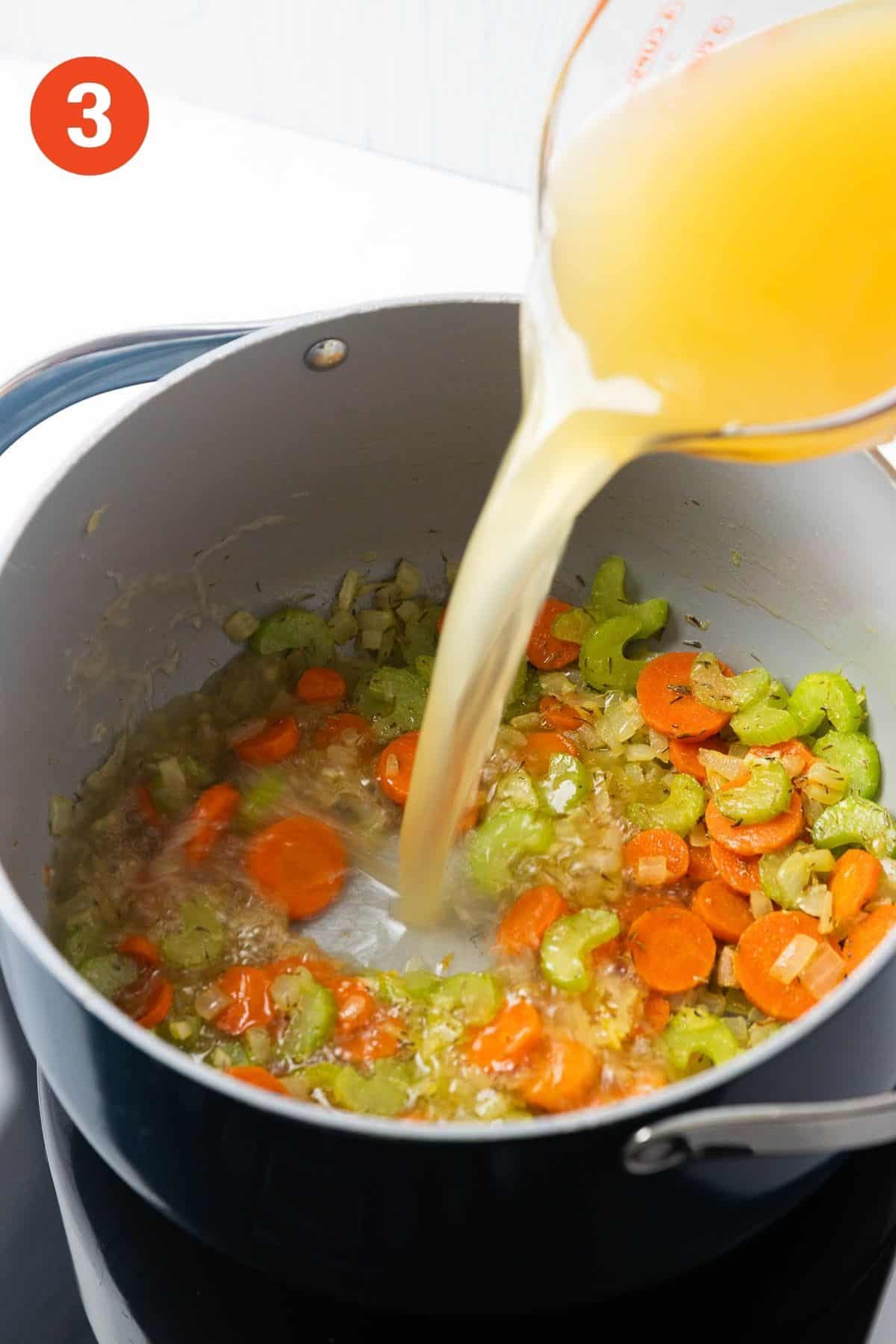 Adding the broth the pot of cooked vegetables.