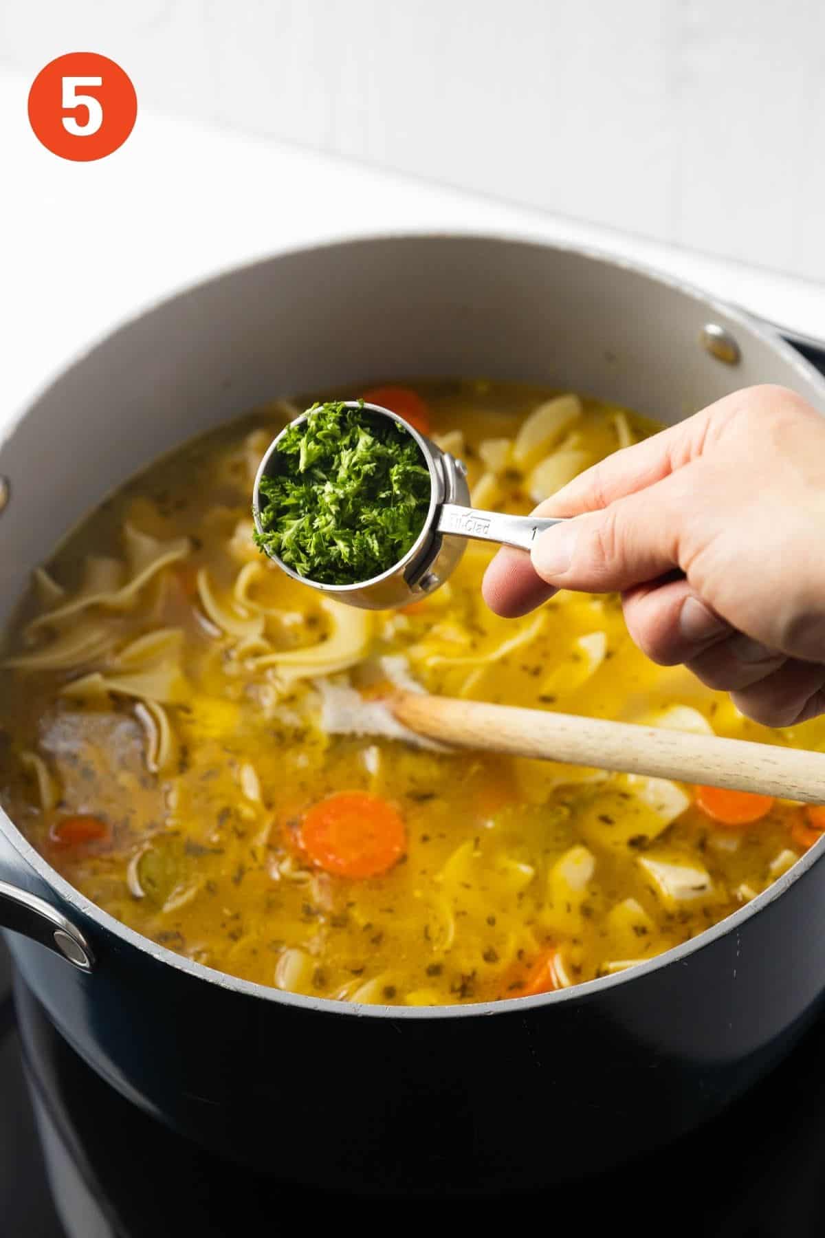 Adding some chopped parsley to the soup.