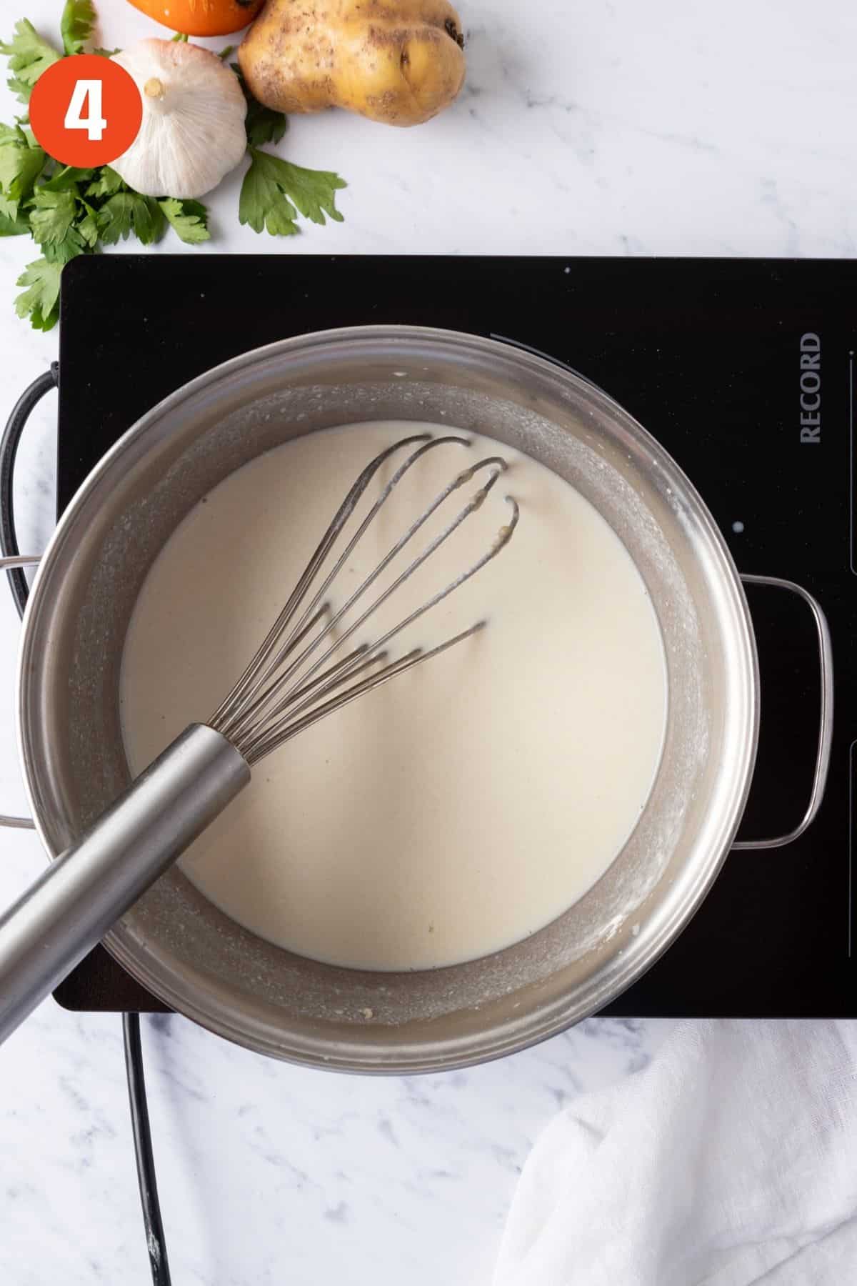 Milk poured into the roux and mixed.