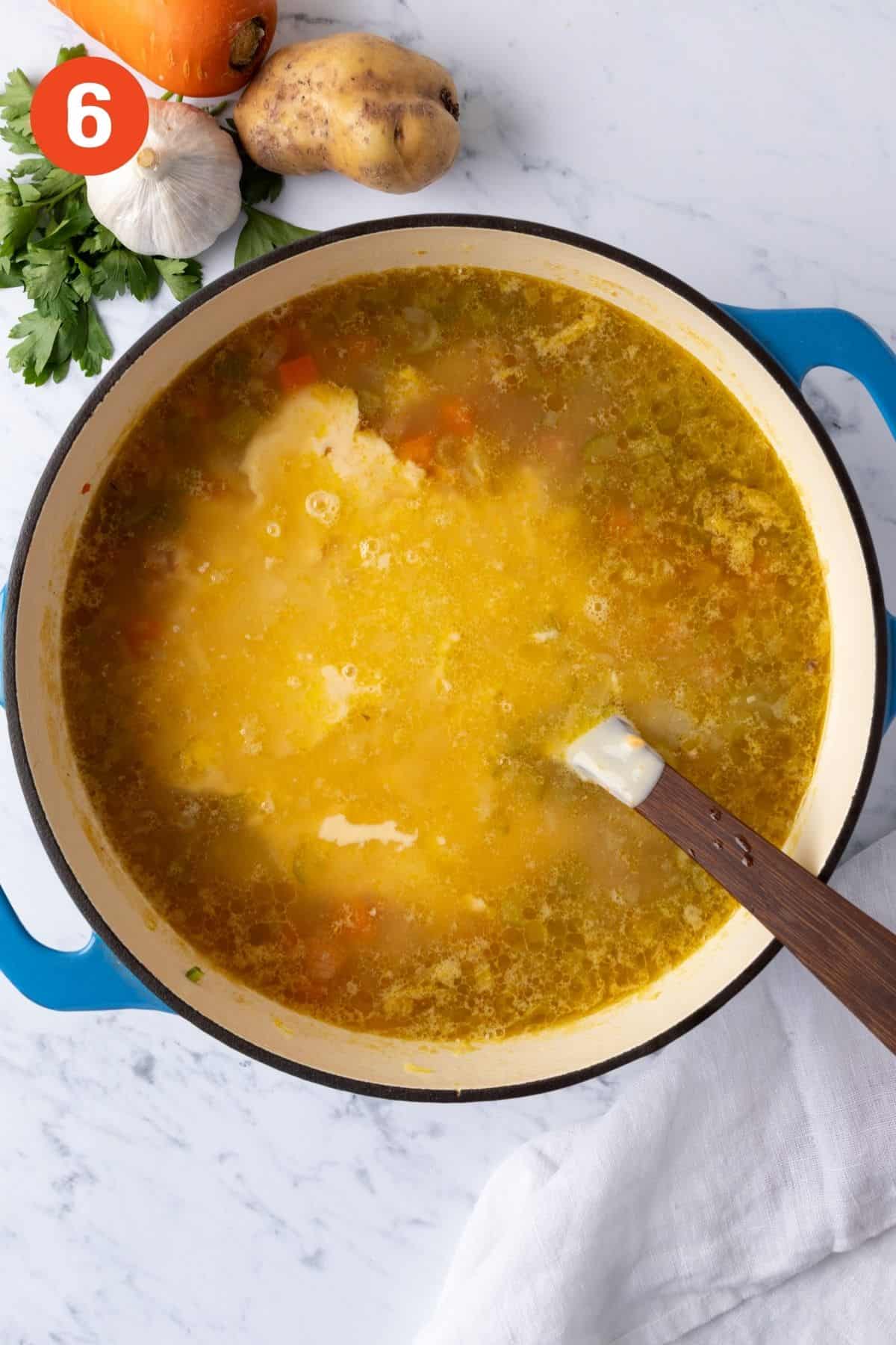 The cheese roux poured into the ham soup.