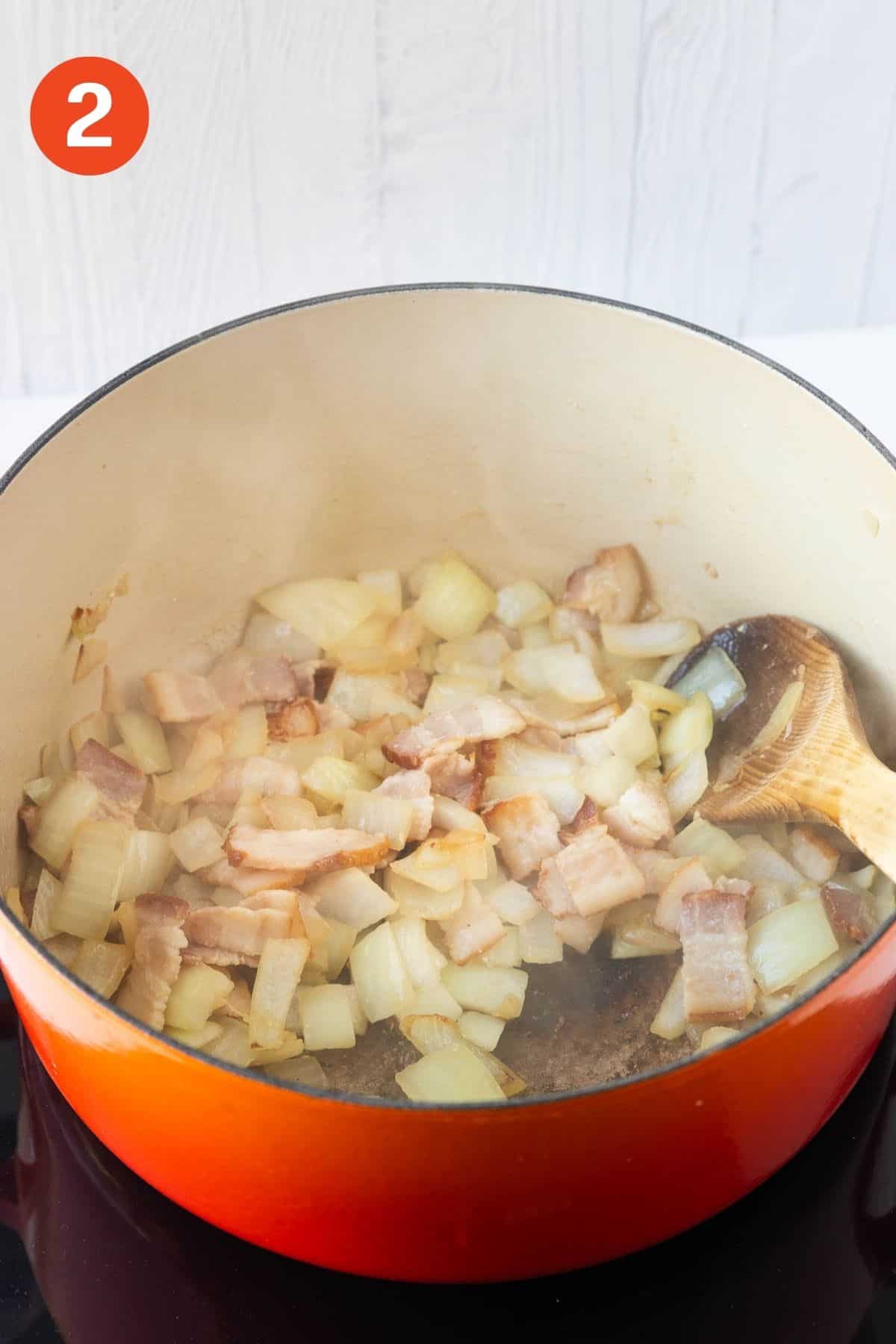 A large pot cooking bacon and onions.