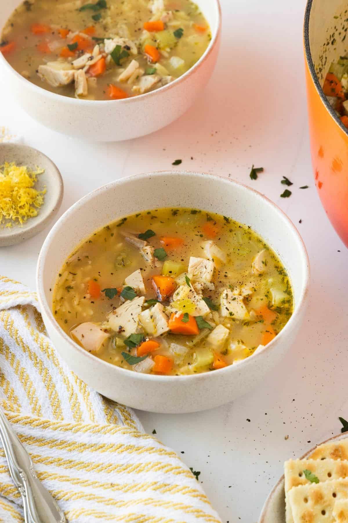 A white bowl with chicken orzo soup.