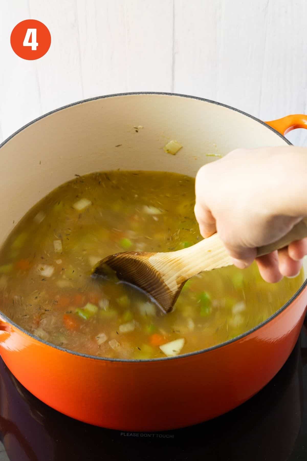 Orzo added to the stock and mixed.