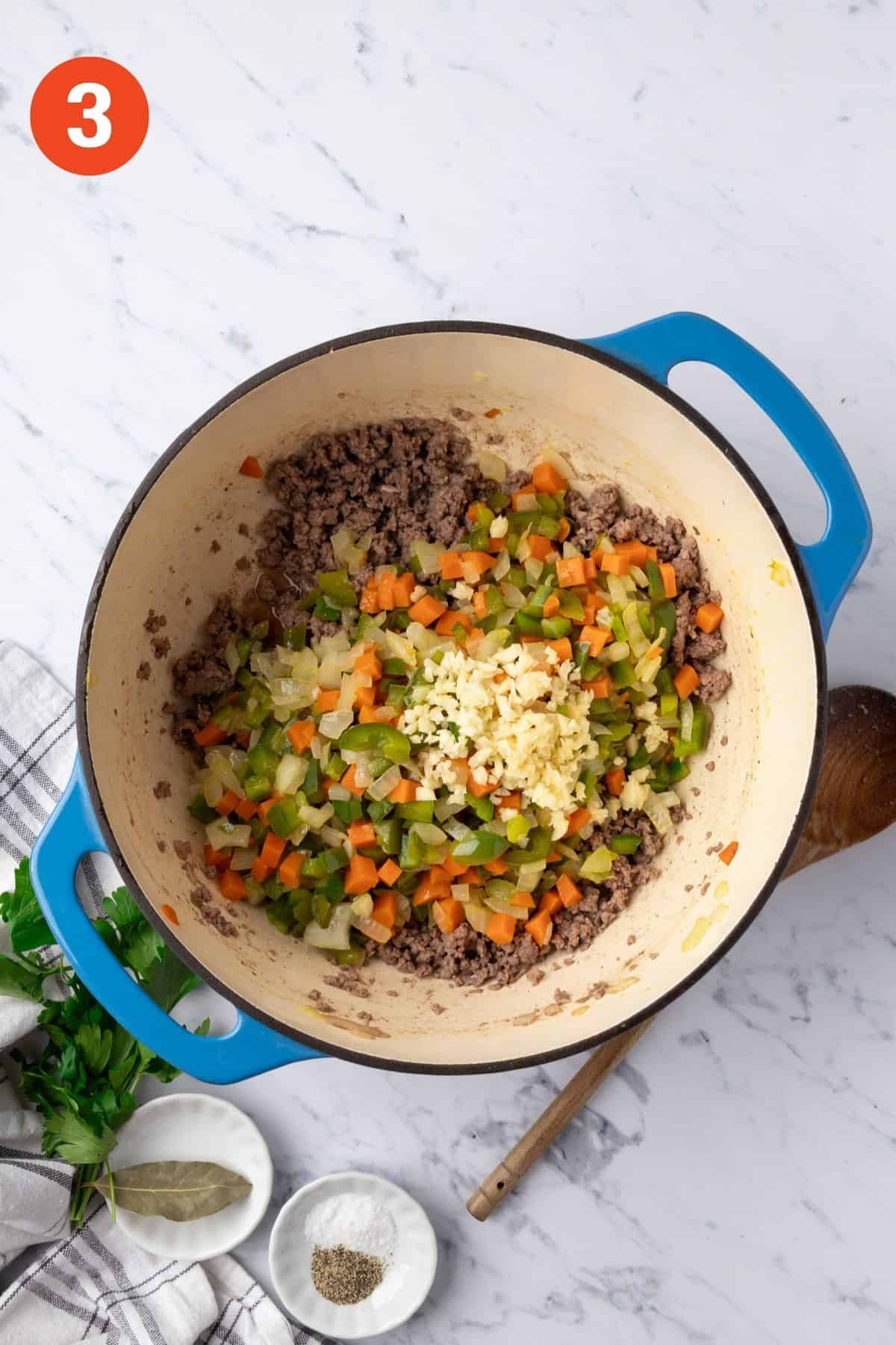 Vegetables and garlic added back to the pot with the ground beef.