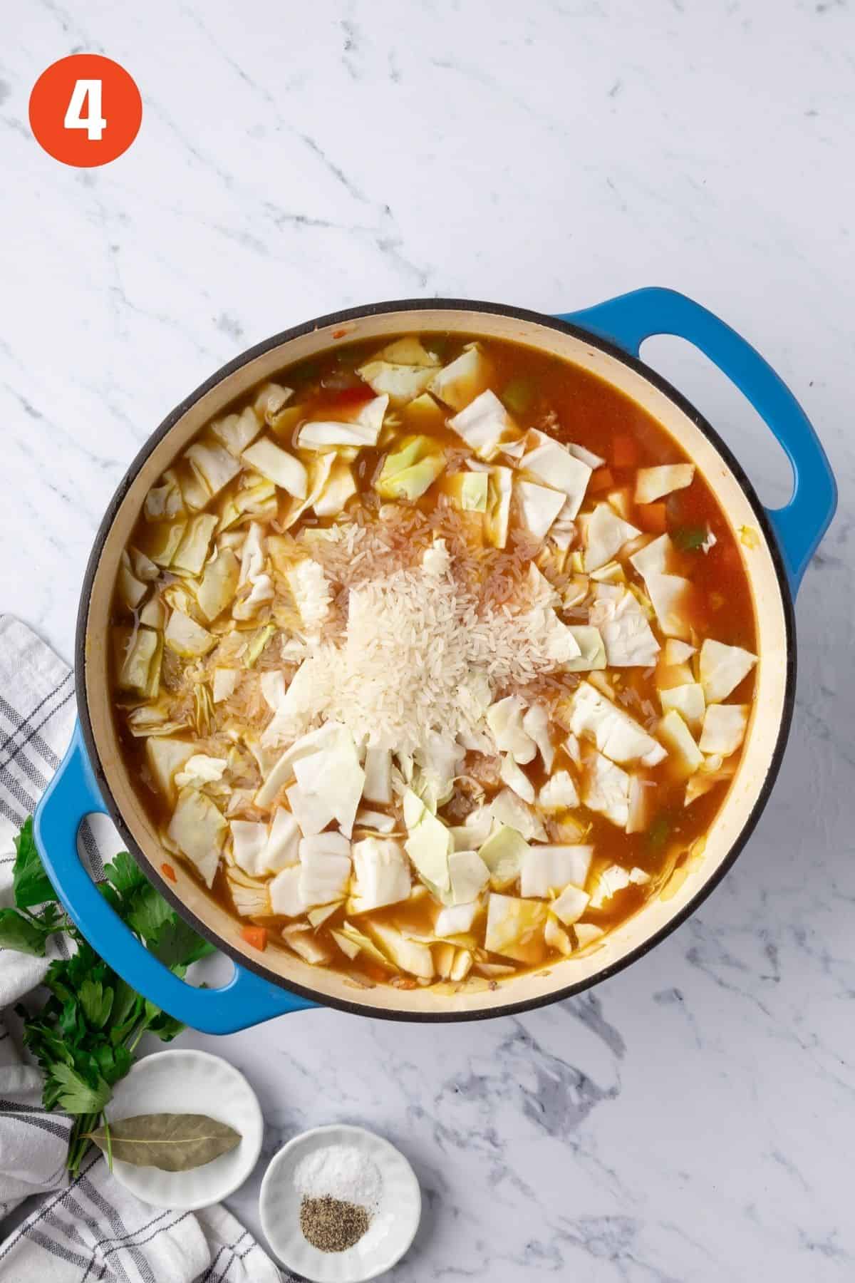 Broth, cabbage, rice, and tomatoes added to the pot.