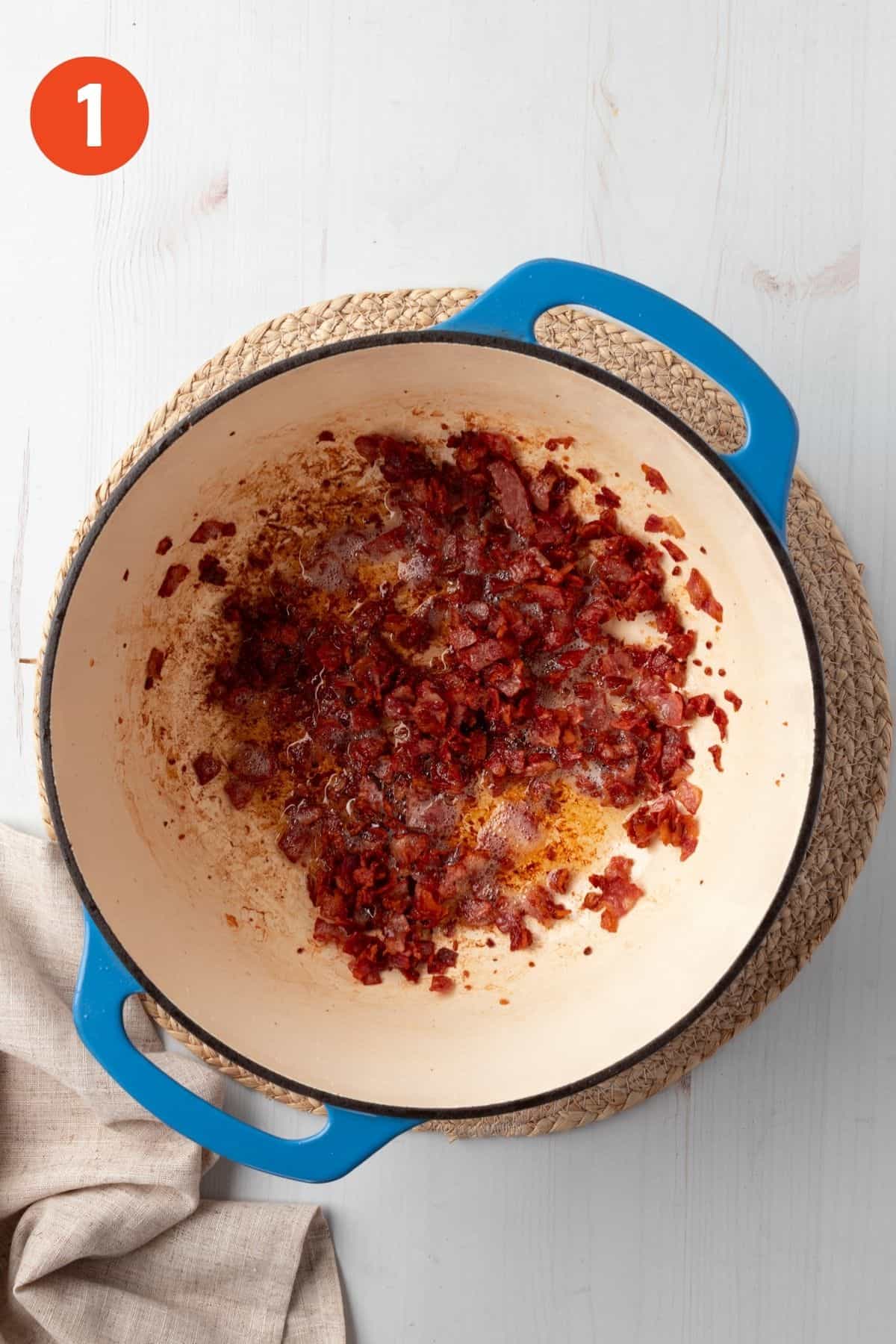 Chopped bacon cooking in a pot.