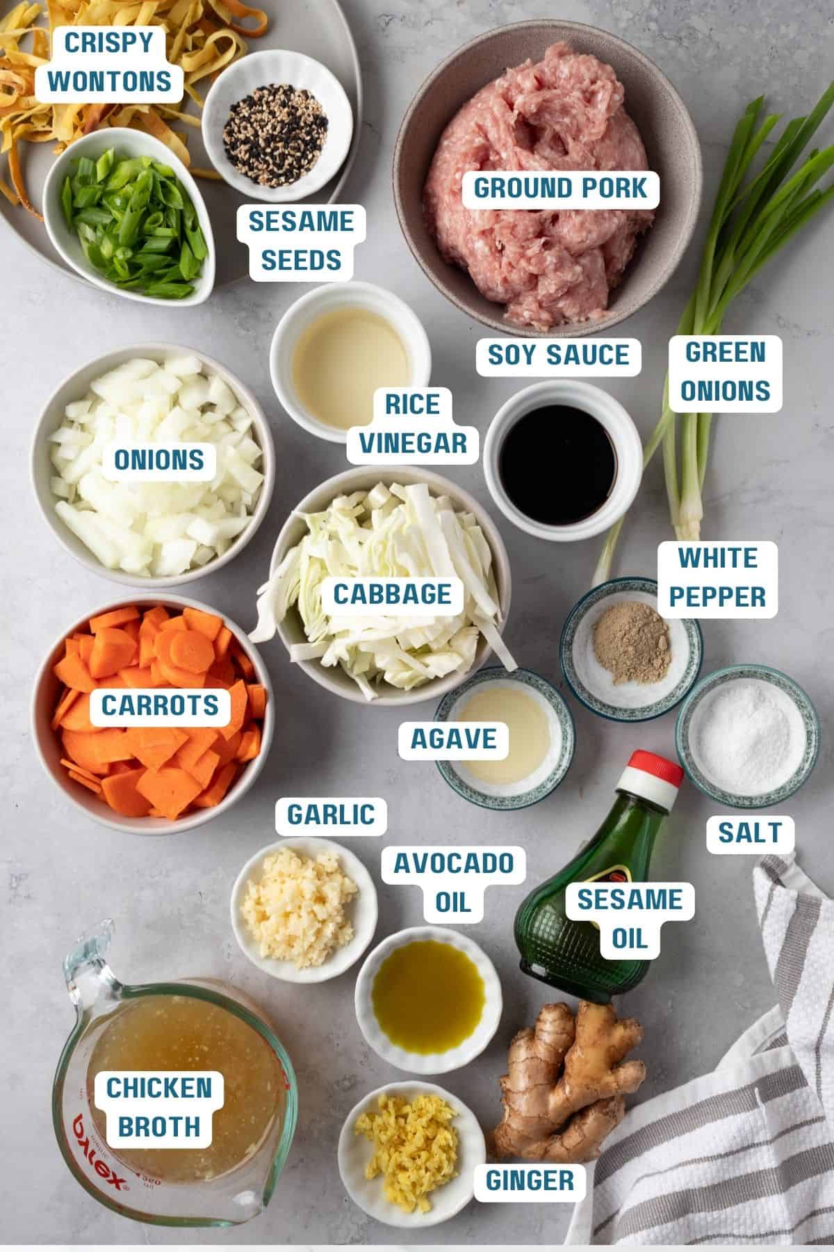 Ingredients to make this egg roll soup recipe in bowls on a table.