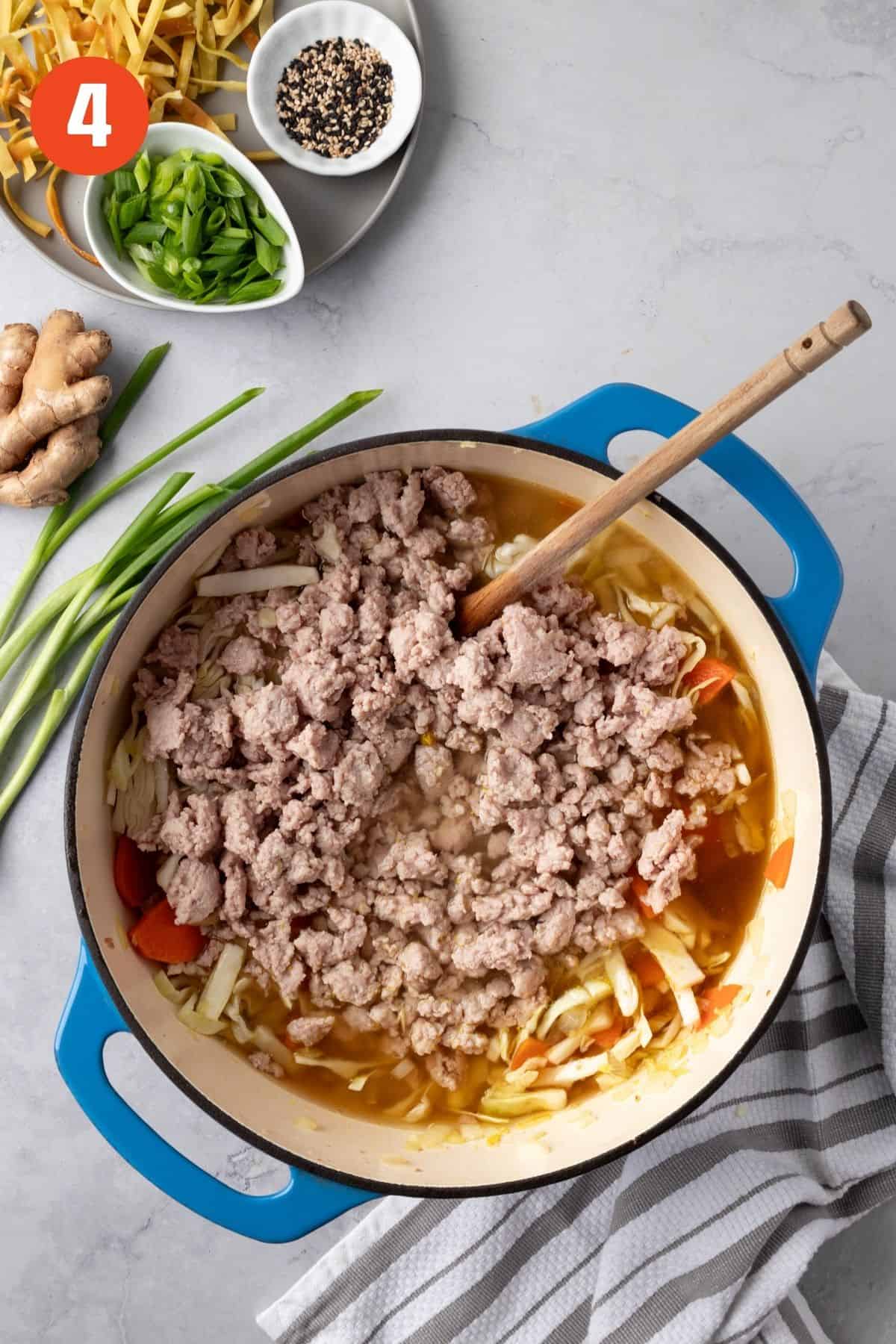 Broth, soy sauce, rice vinegar, and ground pork added to the dutch oven.