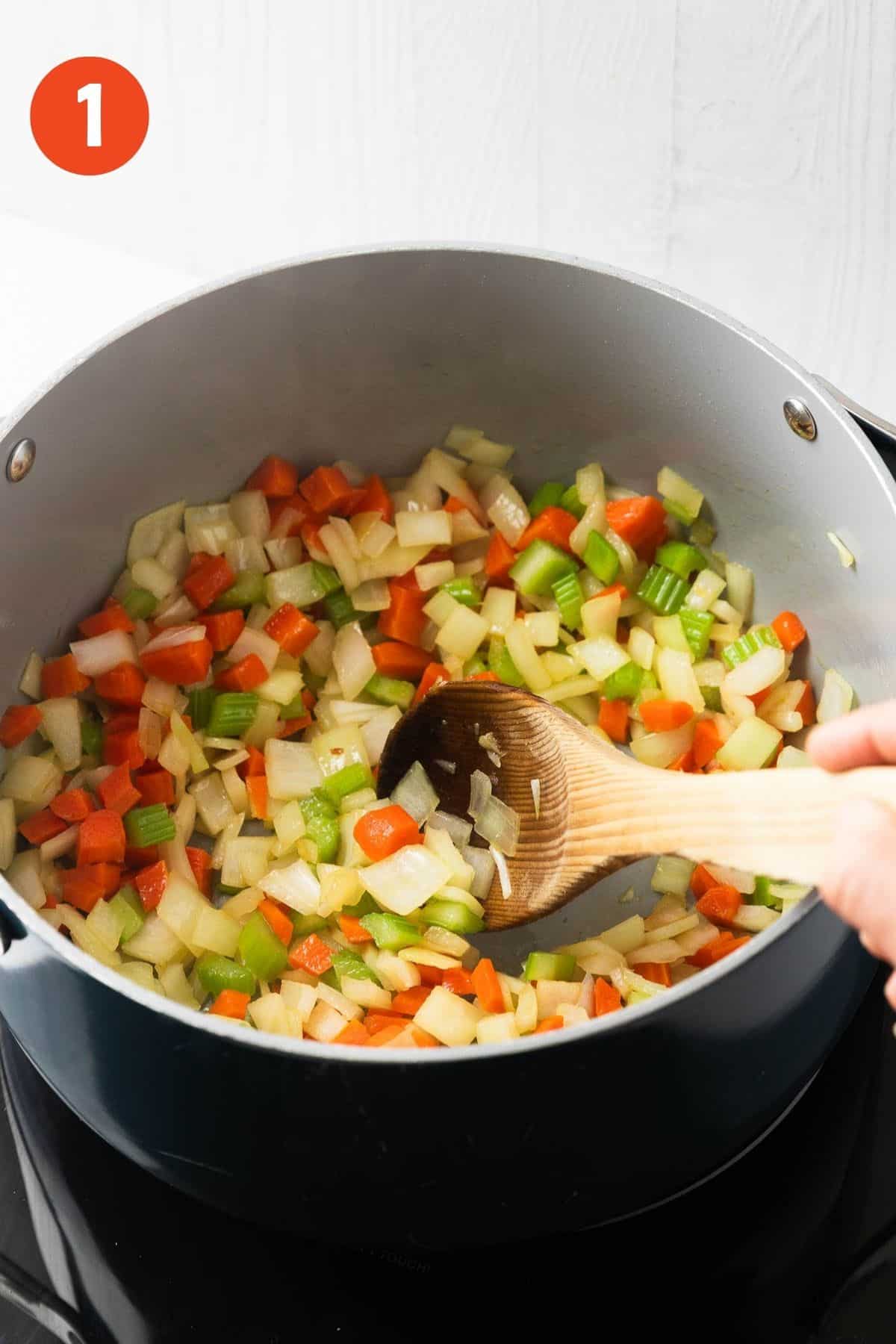 Onion, carrots, and celery in a pot.