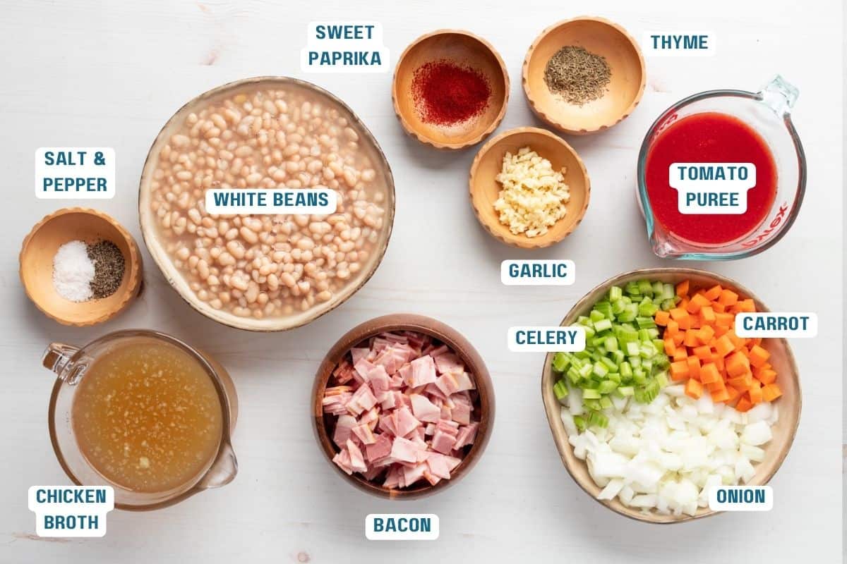 Ingredients to make beans with bacon soup in bowls on a table.