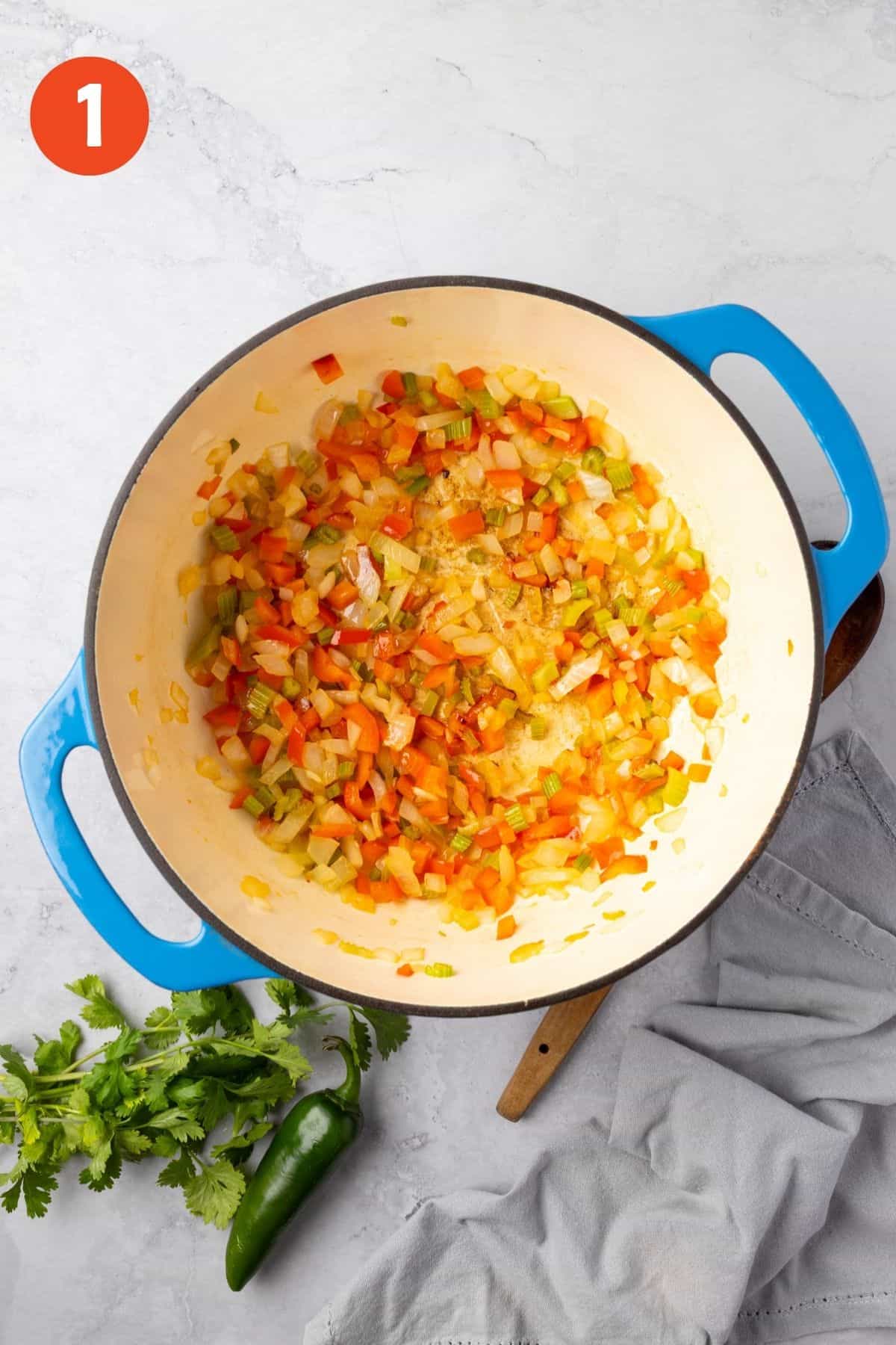Onion, celery, and bell pepper cooked in a large pot.