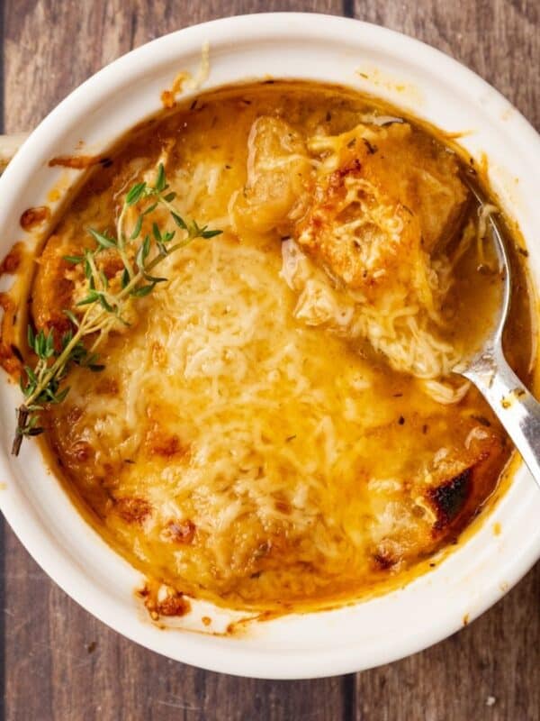 A bowl of Panera French onion soup with a spoon resting in the dish.