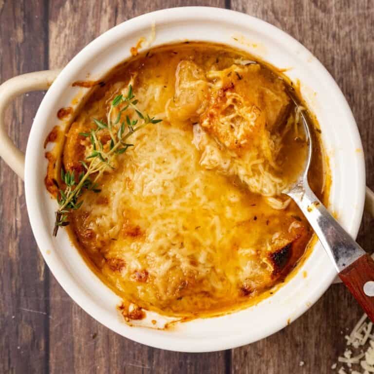 A bowl of Panera French onion soup with a spoon resting in the dish.