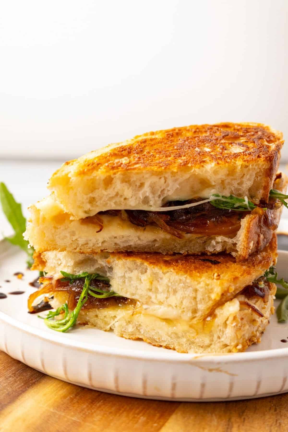 French onion grilled cheese cut in half and stacked on top of each other.