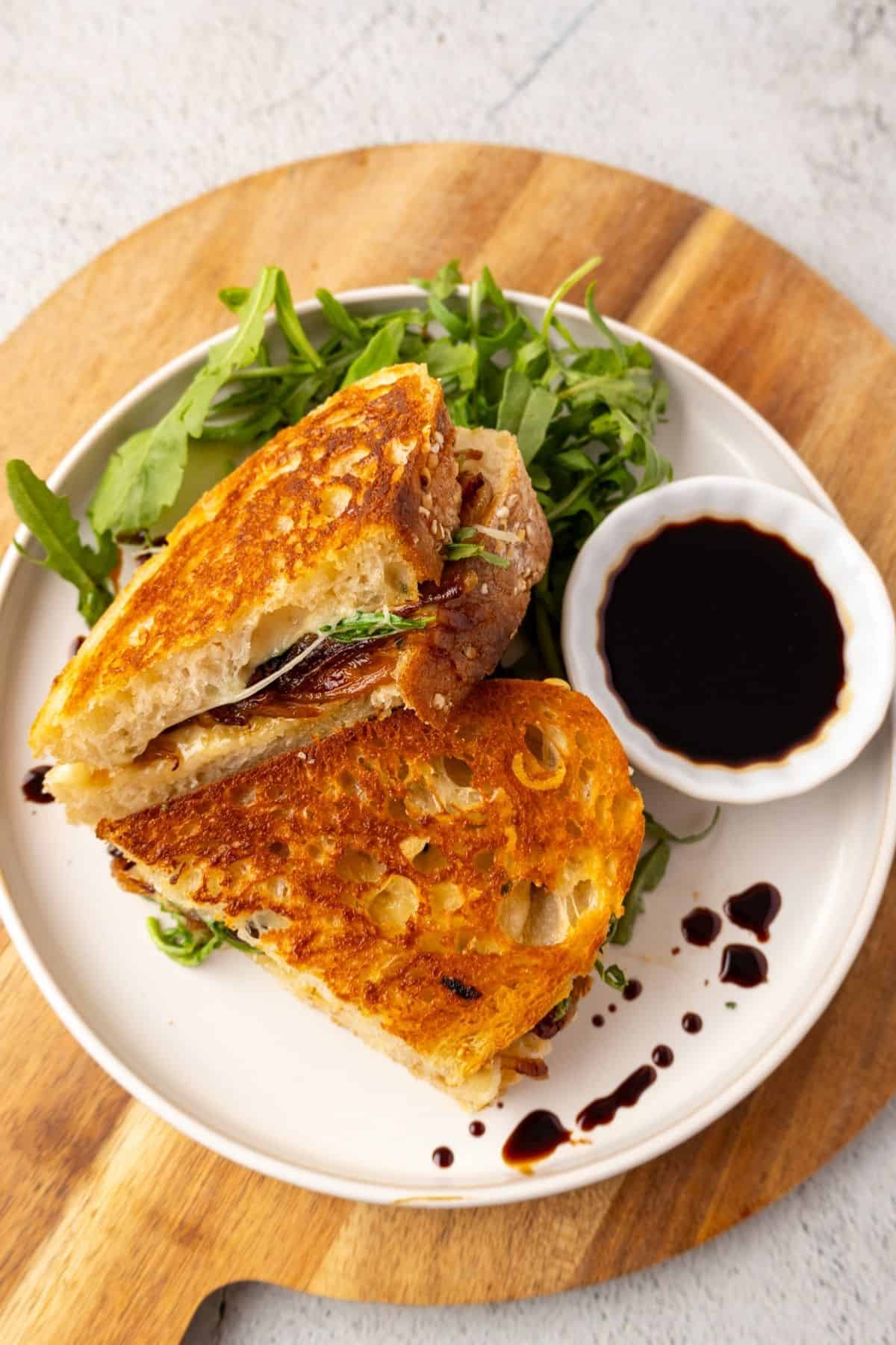 Caramelized onion grilled cheese with some arugula and balsamic glaze on the side.