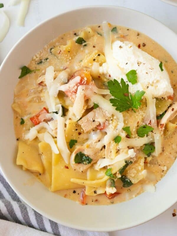 A white bowl of creamy white chicken lasagna soup.