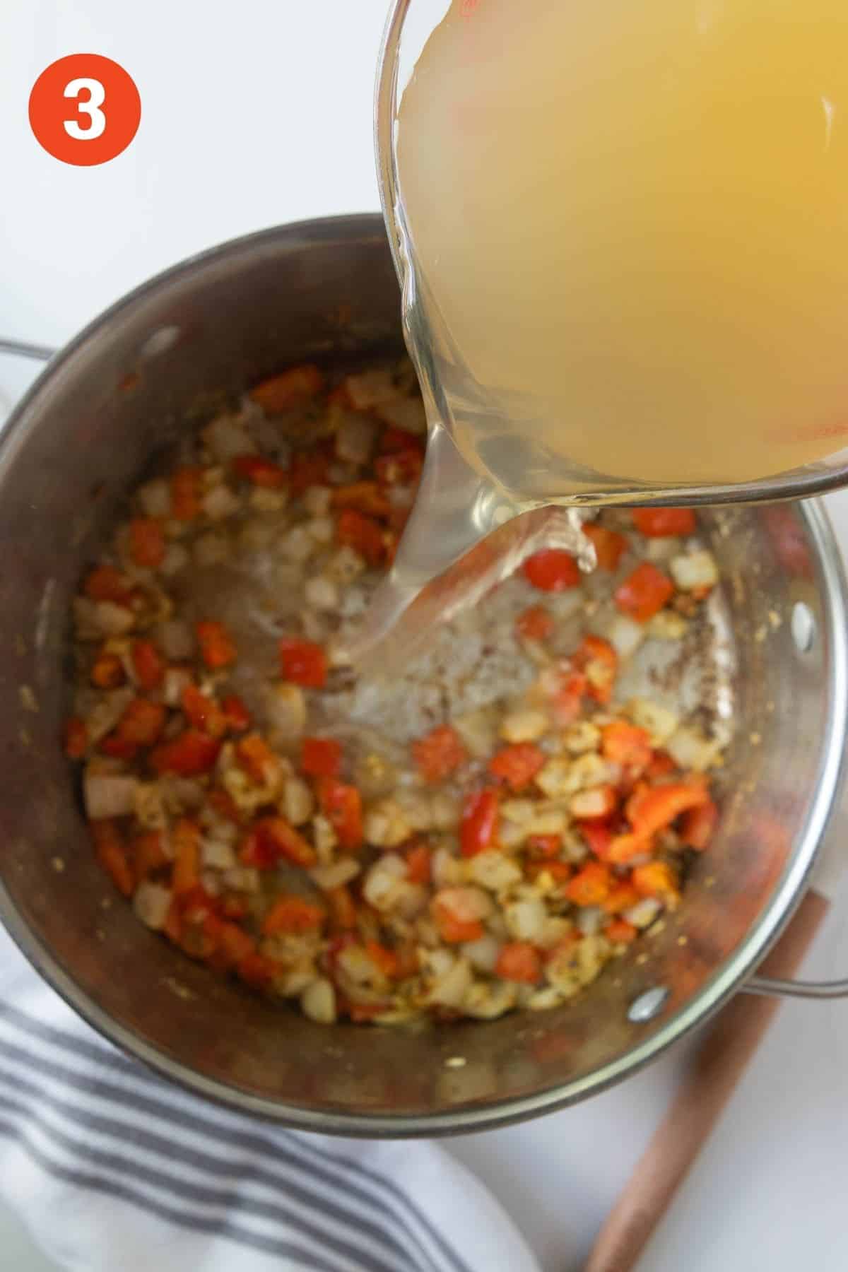 Adding the broth to the pot of vegetables.