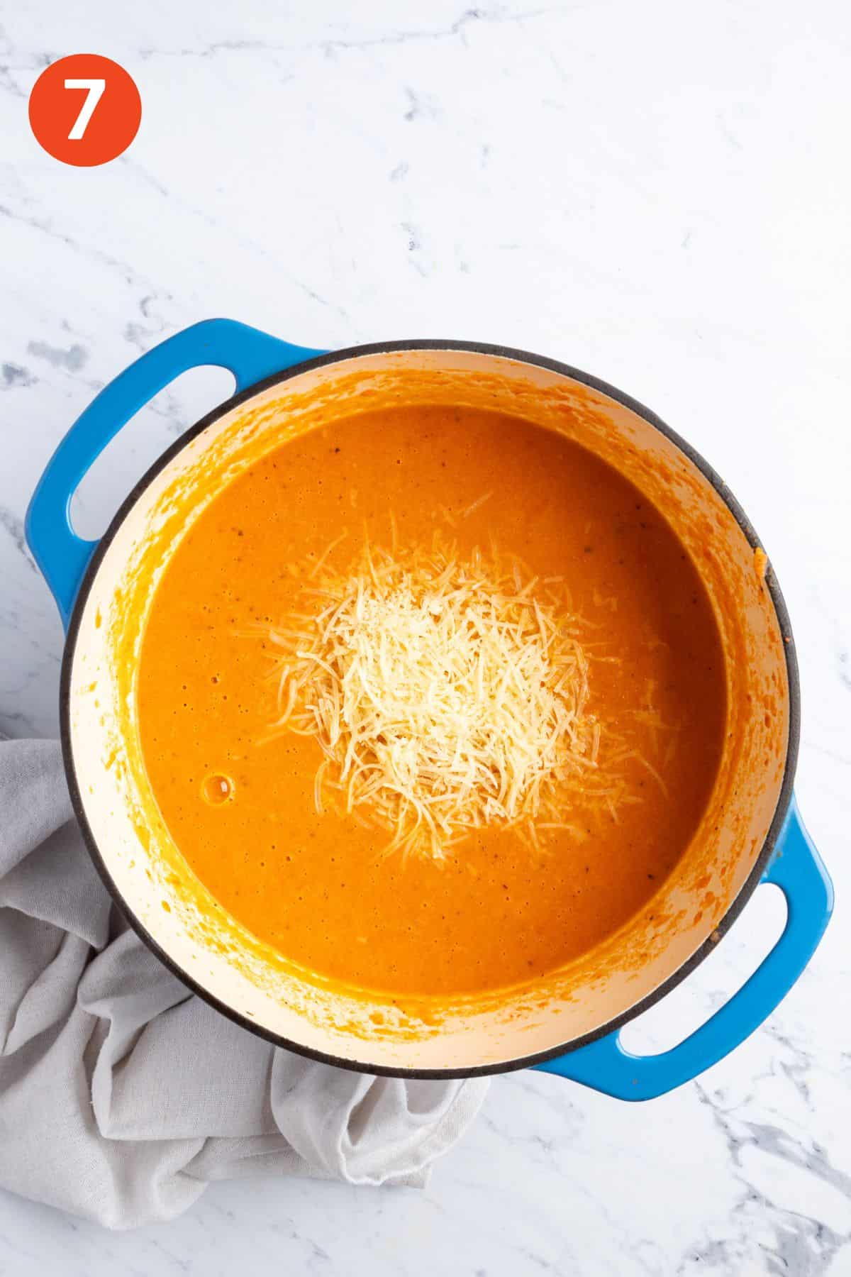 Adding the cheese to the pot of soup.