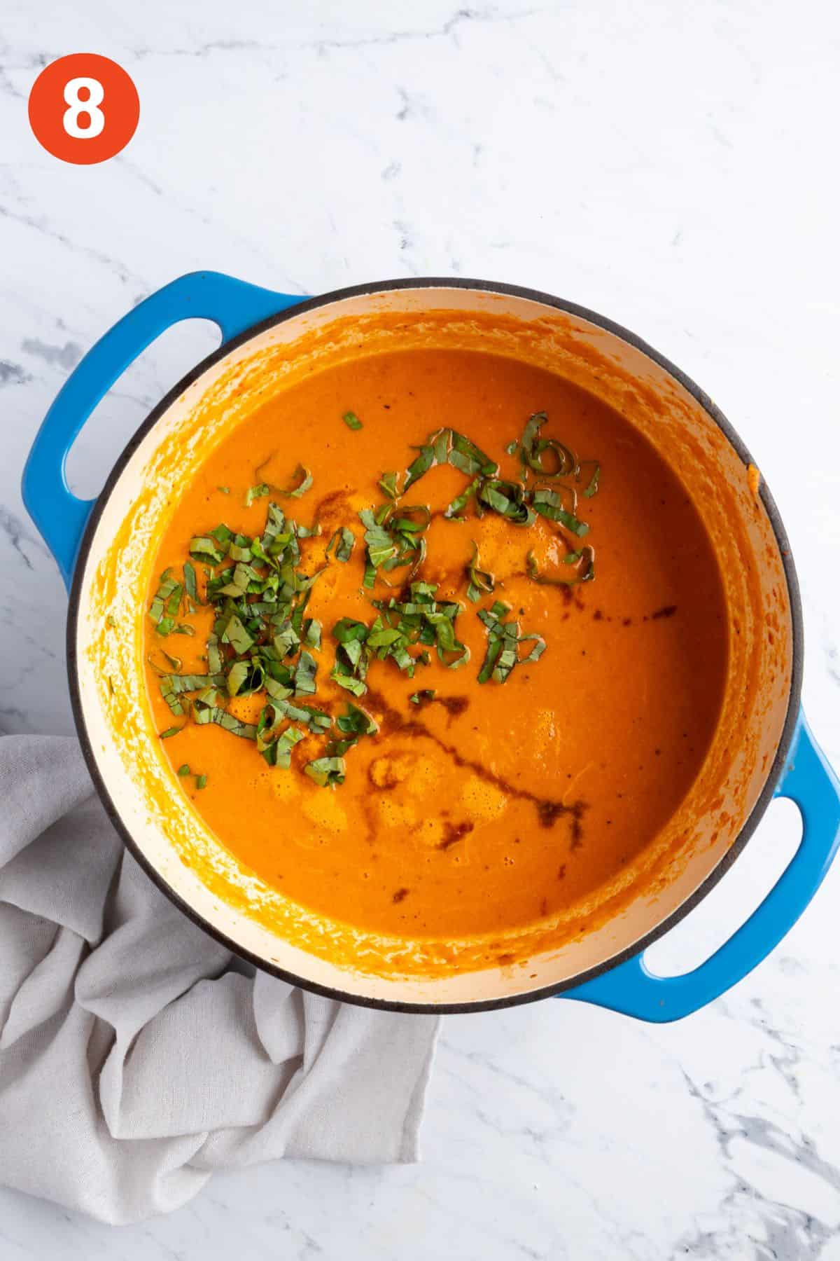 Finishing the tomato soup with fresh basil and balsamic.