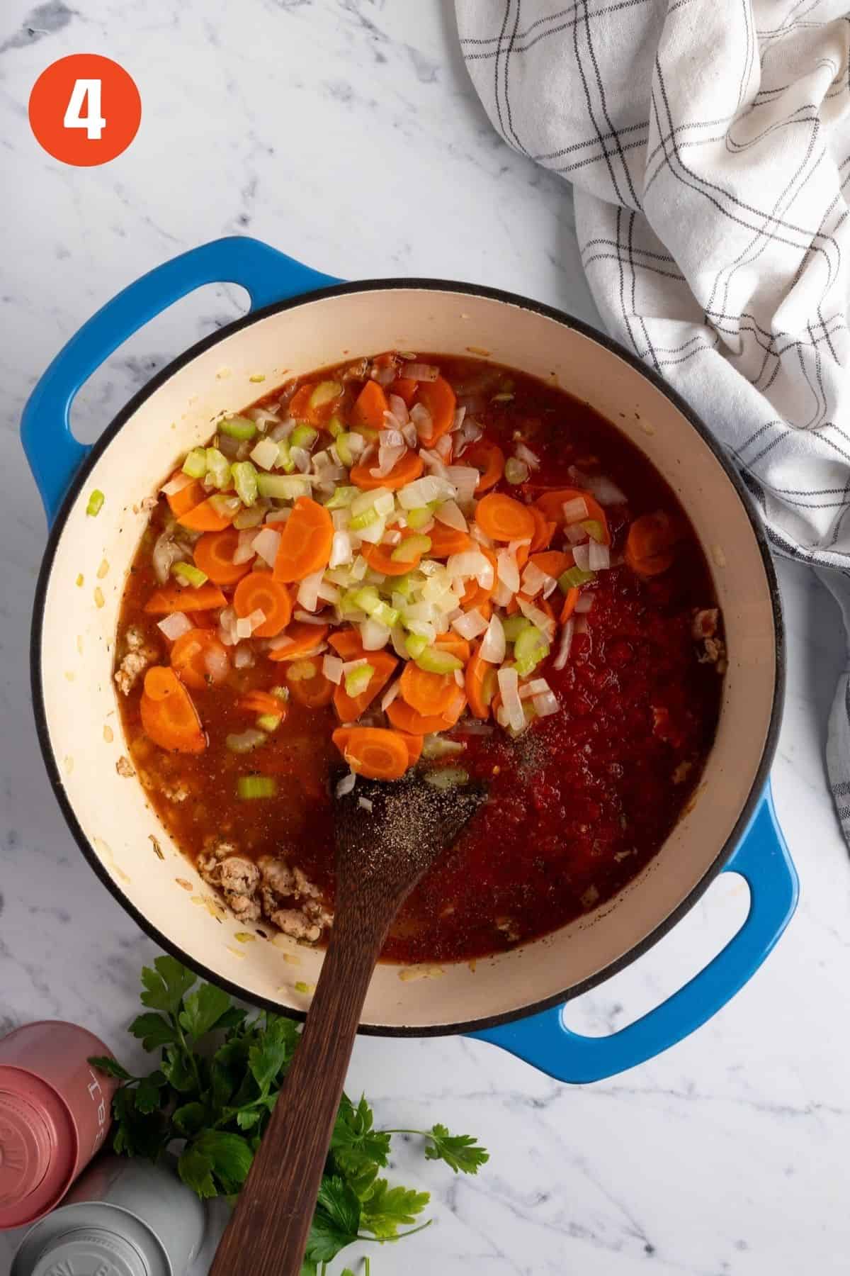 Broth, tomatoes, and vegetables simmering in the pot.
